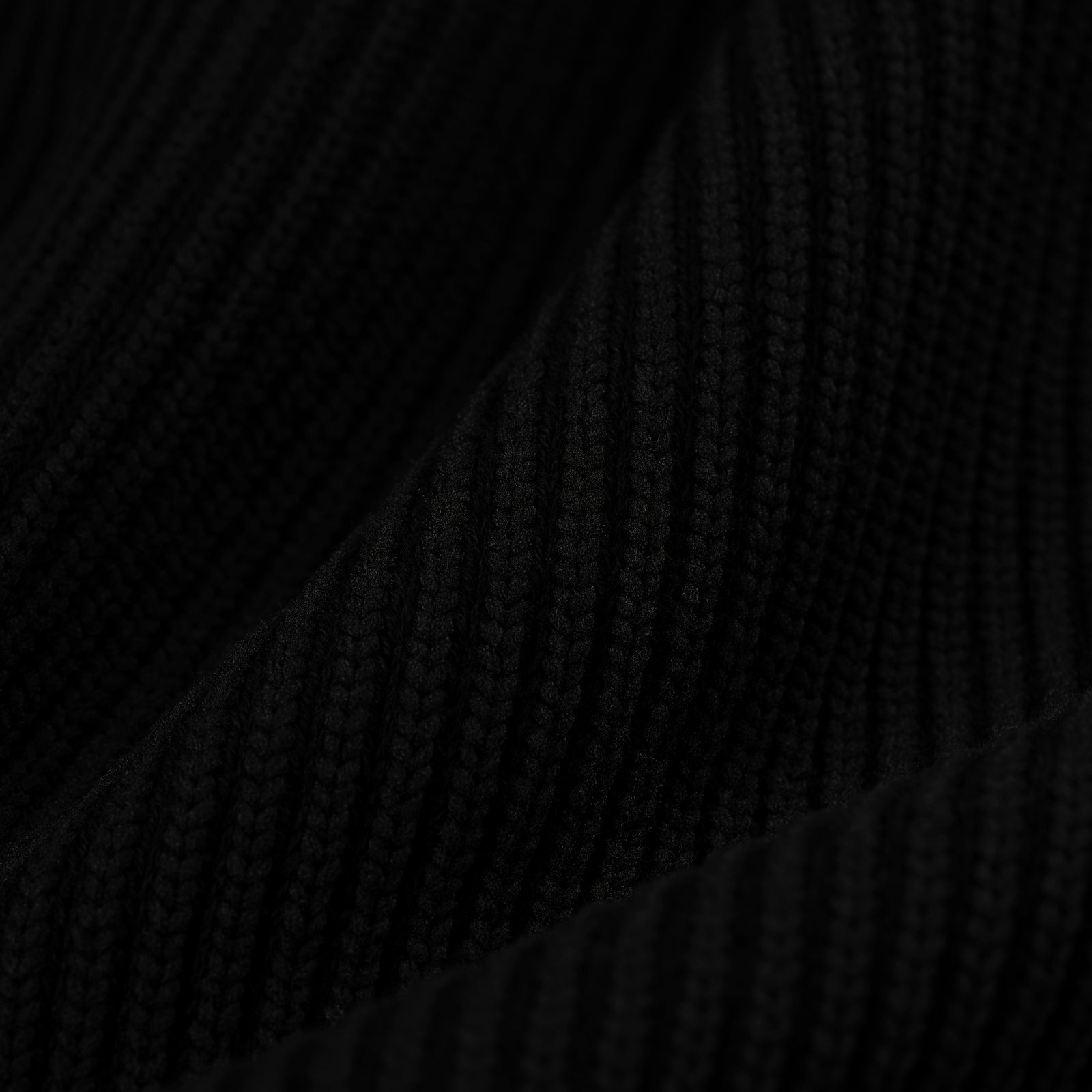 Close-up of a black rib knit wool/cotton blend zip sweater fabric.