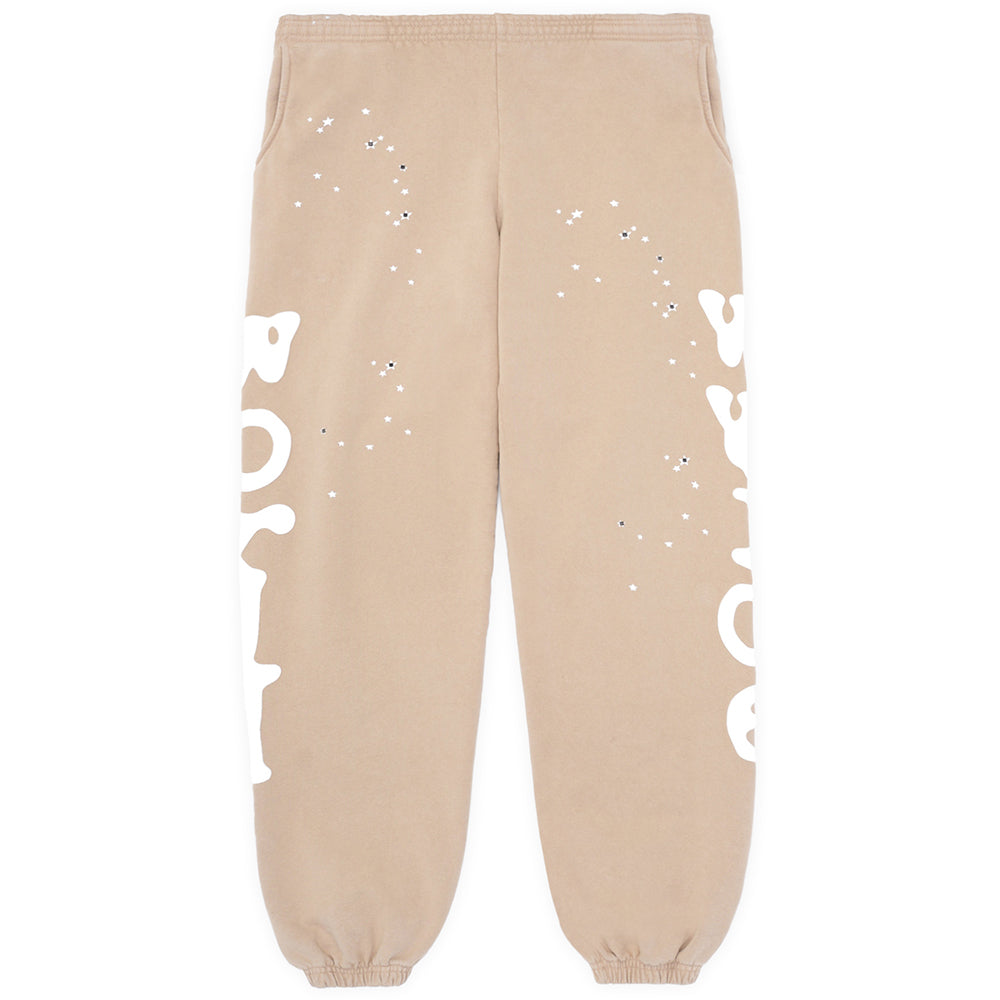 Sand Beluga sweatpants with white puff print "Worldwide" text down both legs and scattered stars.
