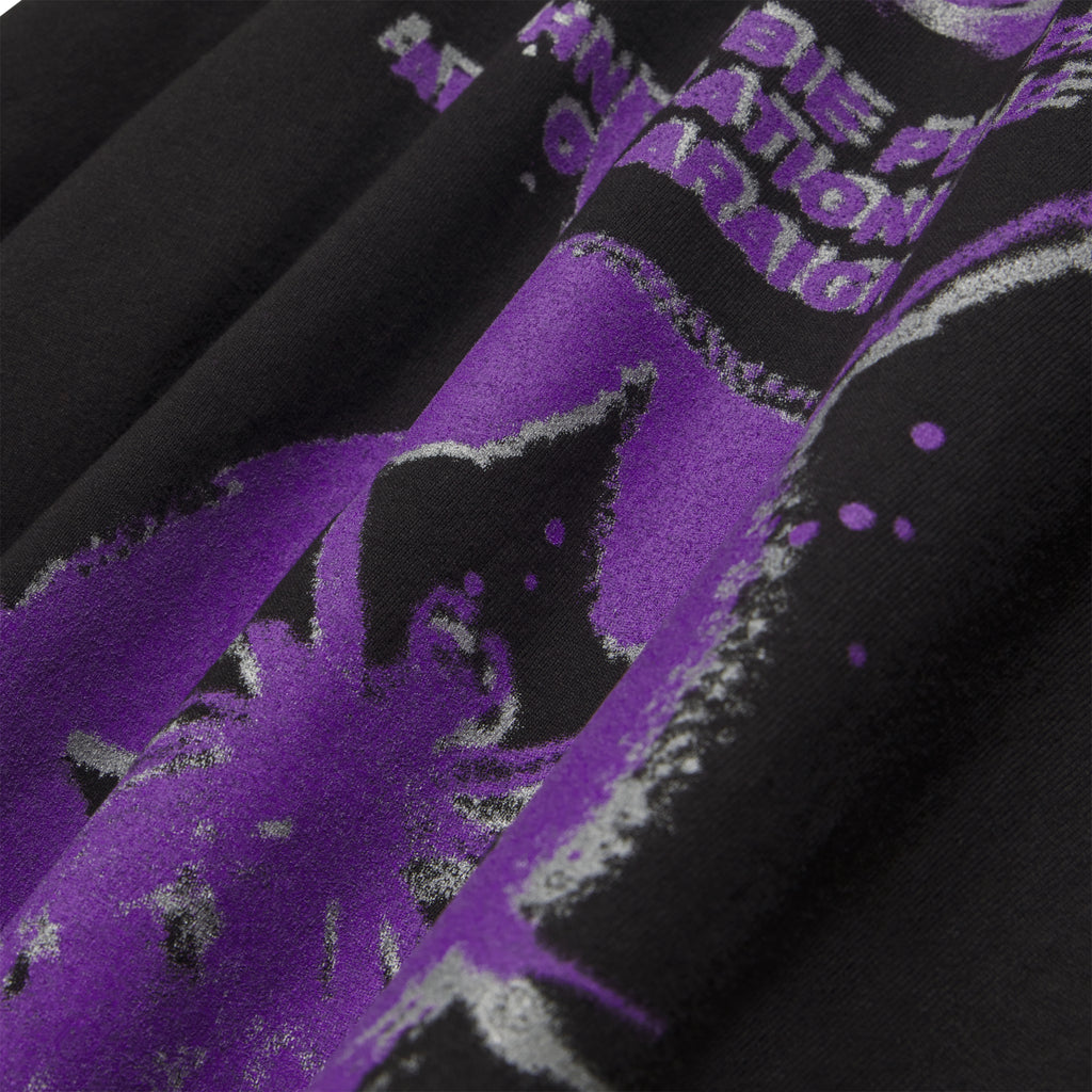 Close-up of a black cotton FRANCE BLUR TEE with a vibrant purple graphic print.