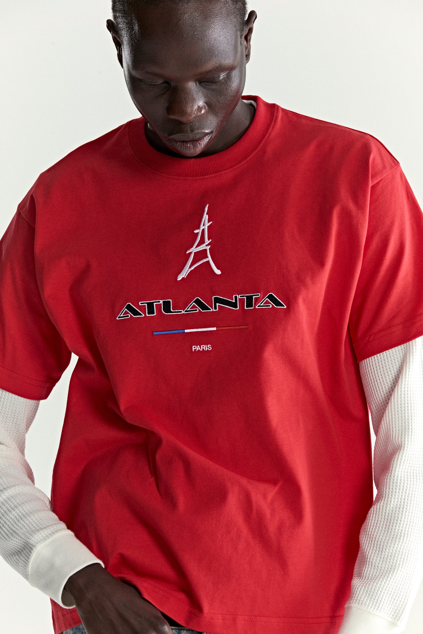 Red 100% cotton ARAIGNÉE TEE with embroidered "ATLANTA PARIS" graphic and Eiffel Tower design.
