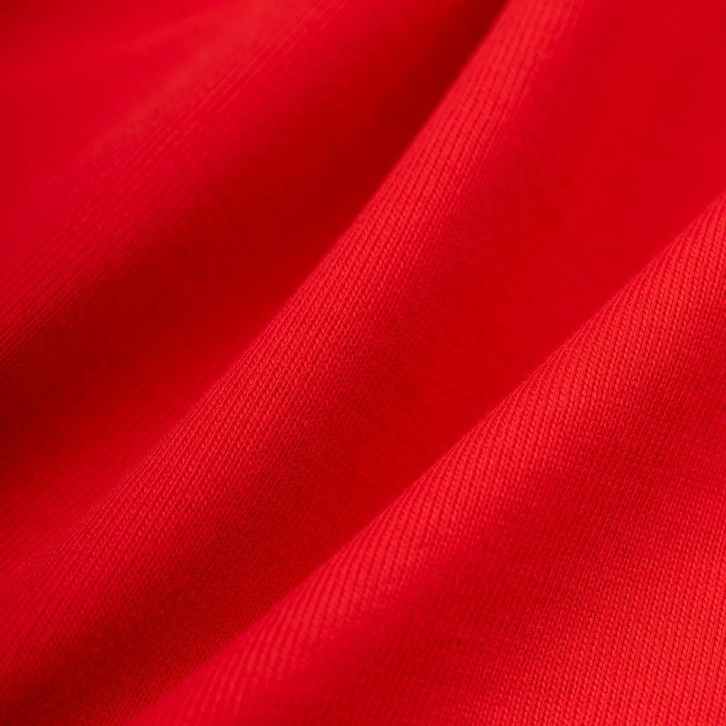 Close-up of a vibrant red 100% cotton tee fabric with soft folds.