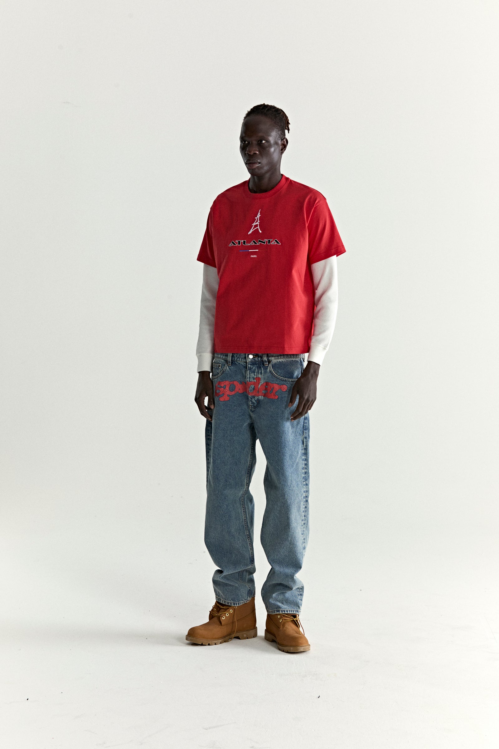Red cotton ARAIGNÉE TEE with embroidered Eiffel Tower graphic, layered over a white long-sleeve shirt.