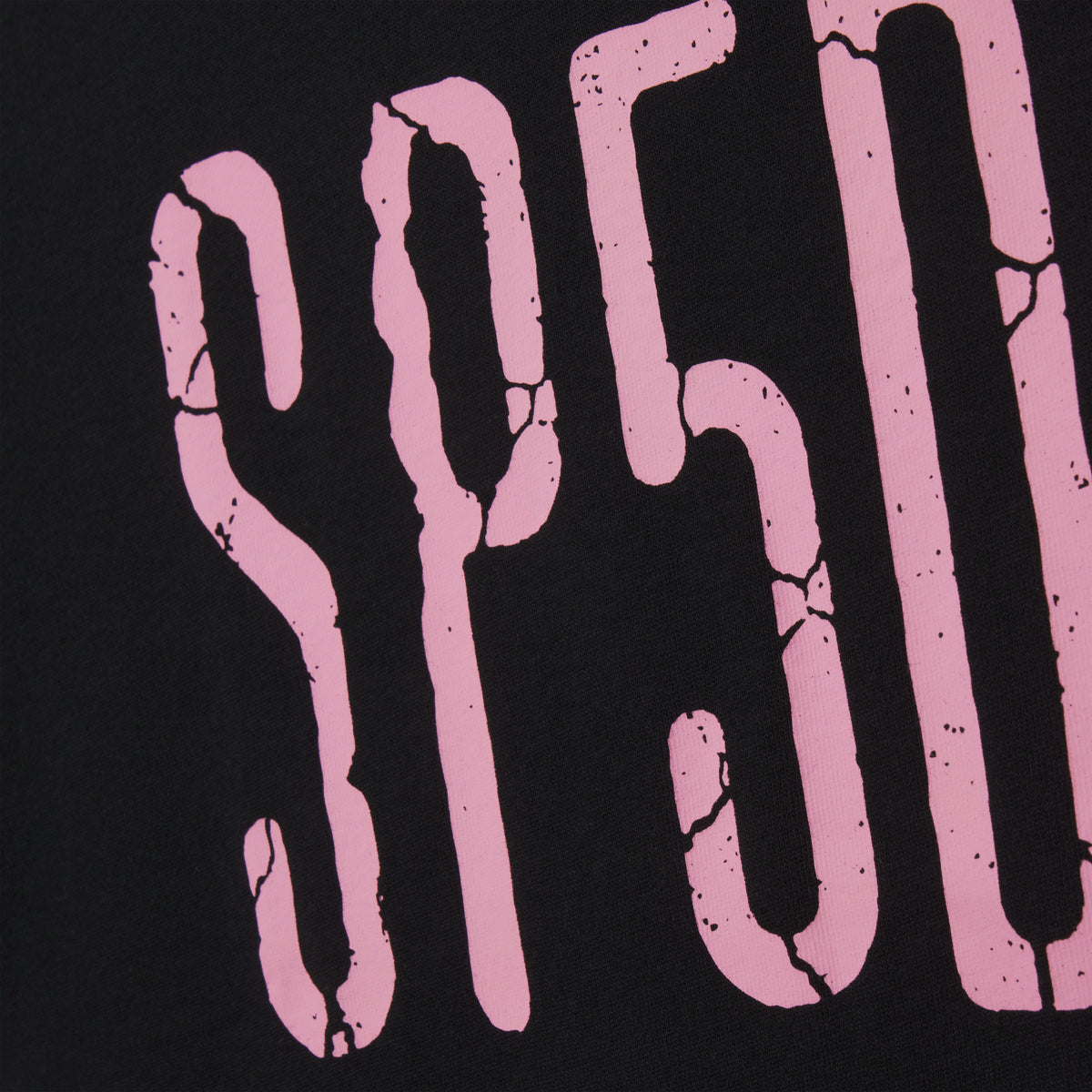 Black 100% cotton tee featuring a pink graphic print with a distressed, cracked texture design.
