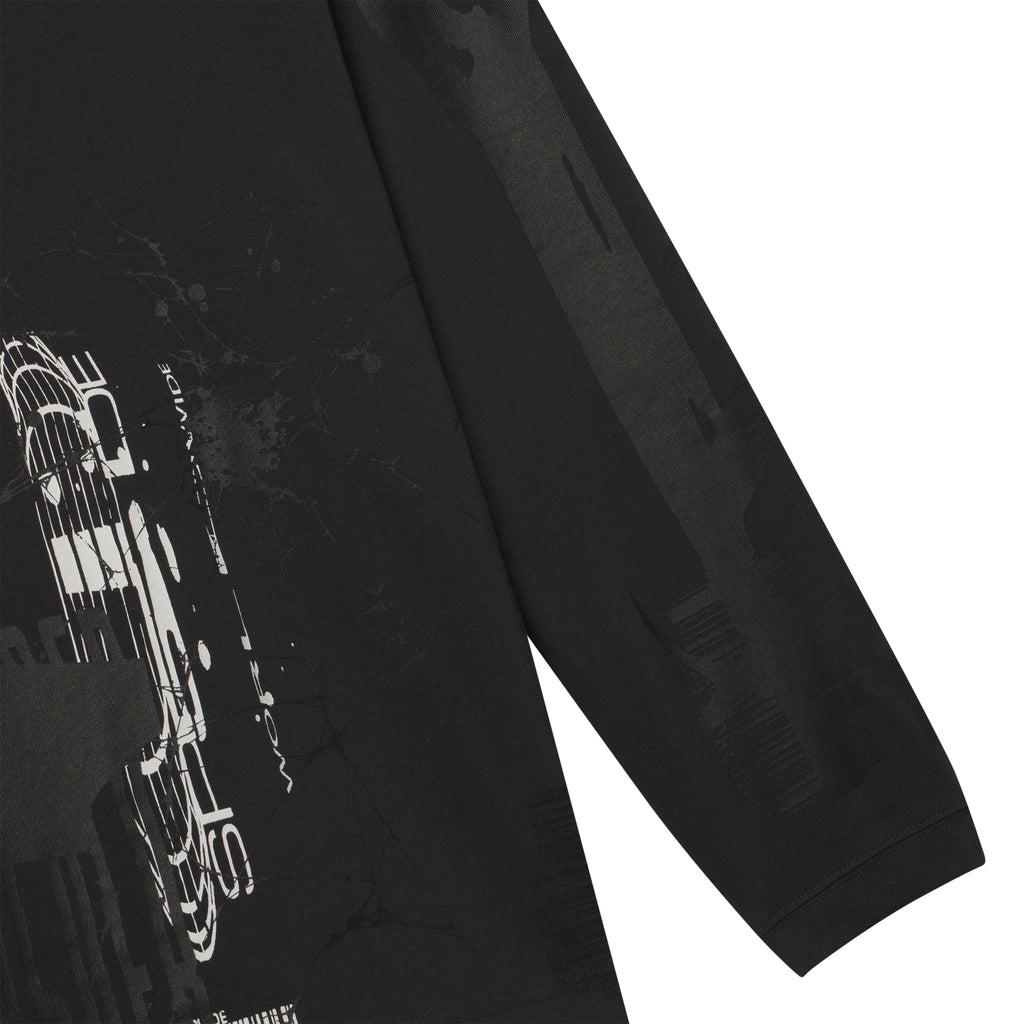 Black 100% cotton long sleeve tee featuring a white and grey fragmented graphic print on the front and sleeves.