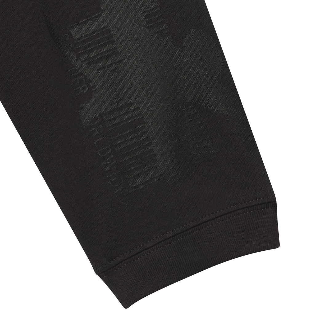 Black 100% cotton long sleeve tee featuring a tonal graphic print of barcodes and text on the sleeve.