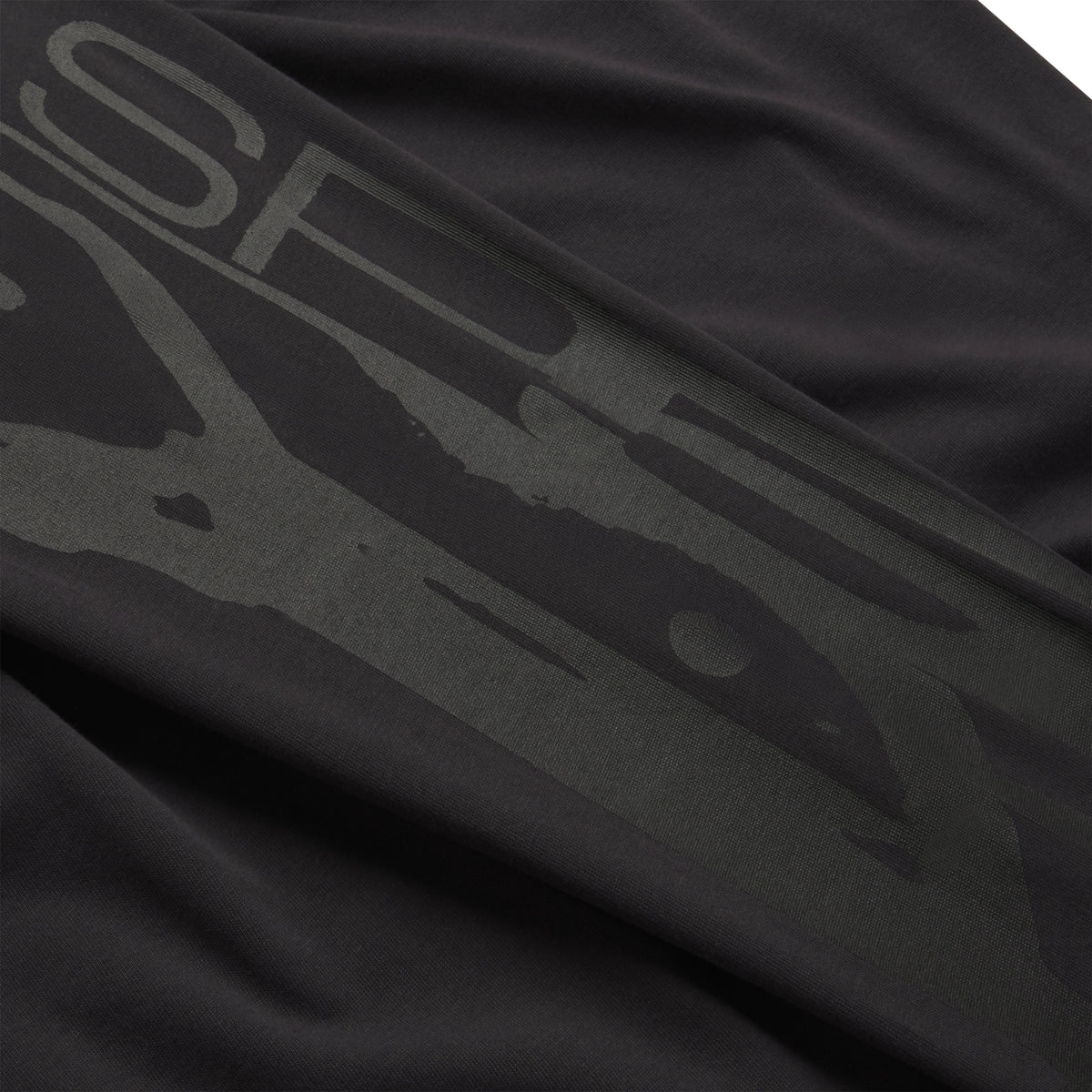 Black 100% cotton long sleeve tee featuring a tonal graphic print design on the sleeve.