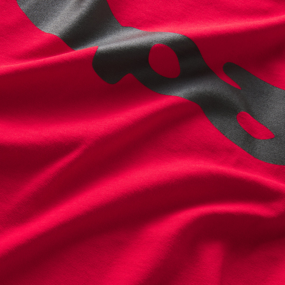 Bright red 100% cotton tee featuring a bold black graphic print design in a standard fit.