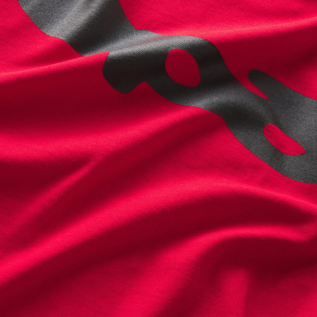 Bright red 100% cotton tee featuring a bold black graphic print design in a standard fit.