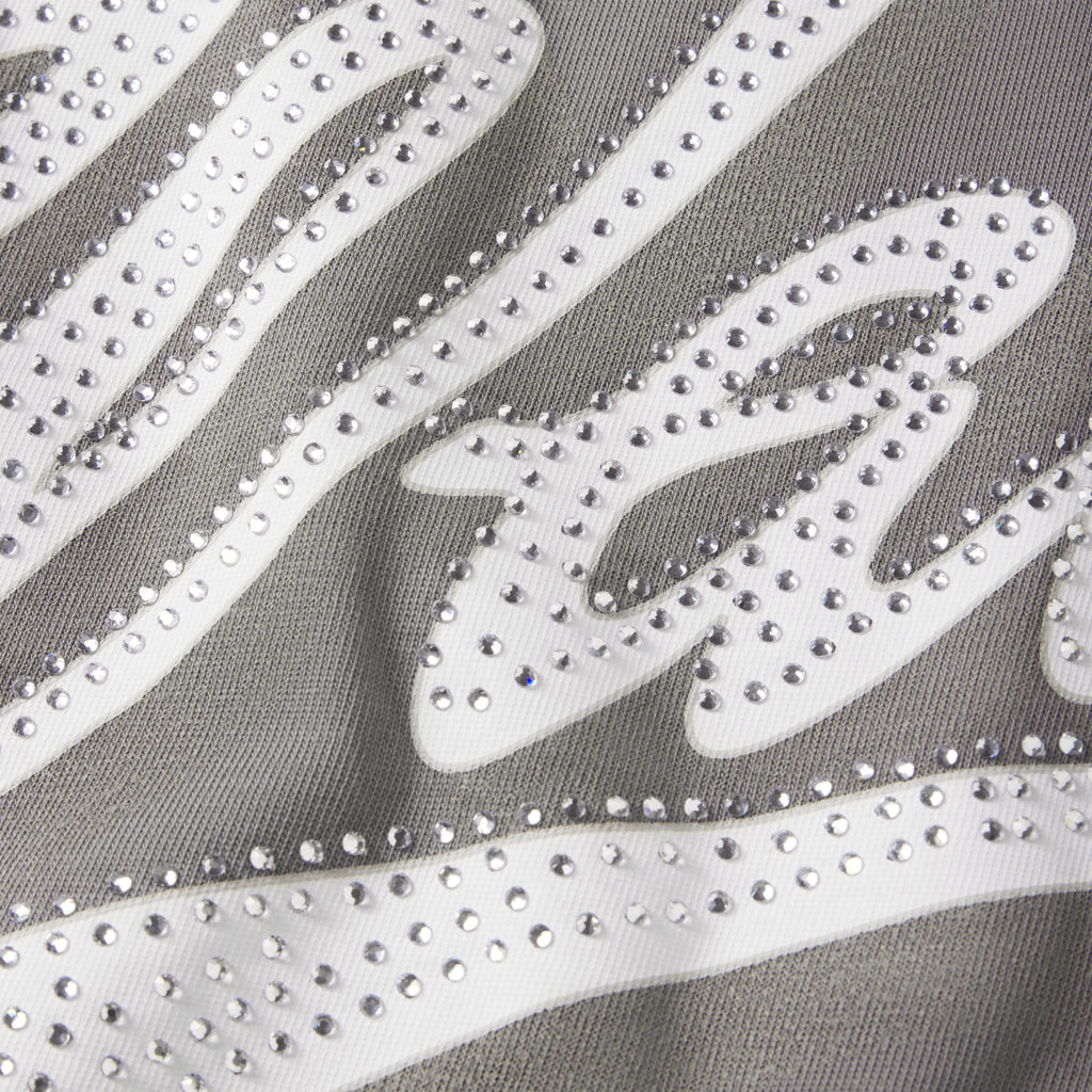 Close-up of a grey cotton tee featuring a white graphic design embellished with sparkling clear rhinestones.