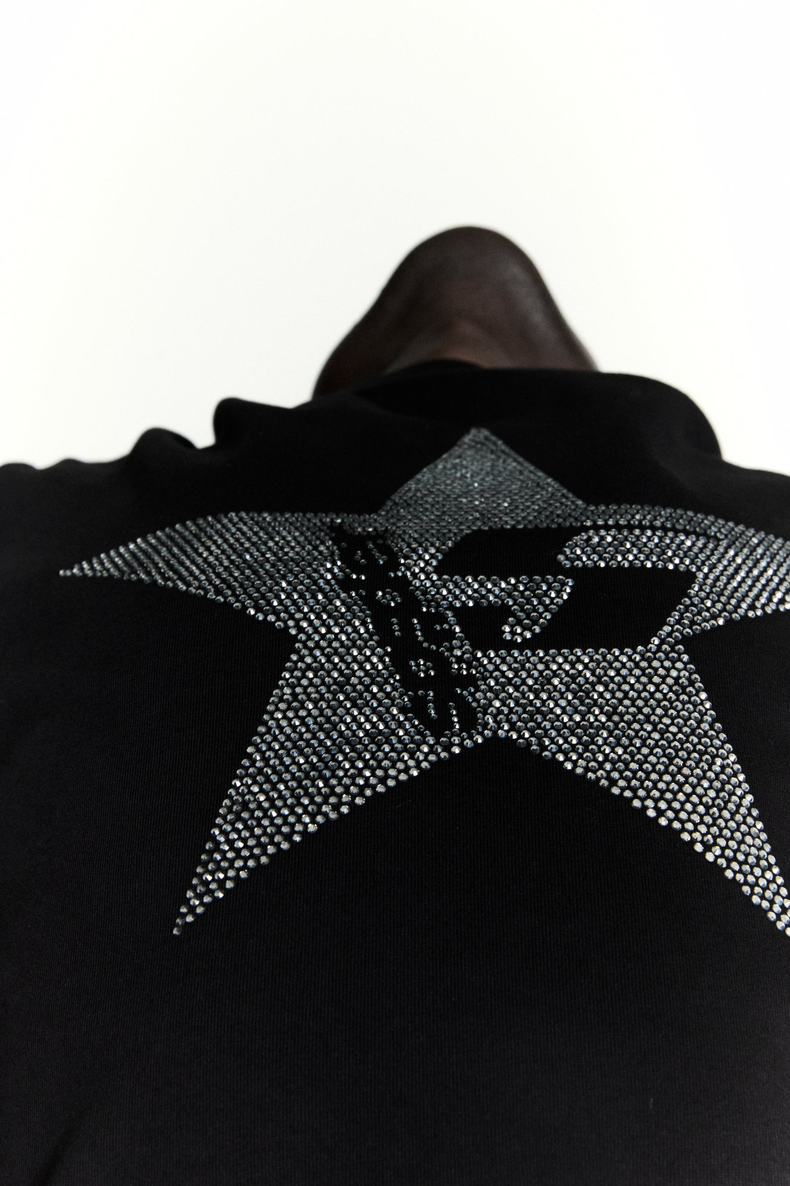 Black 100% cotton tee with a large, sparkly rhinestone 5-star design on the back.