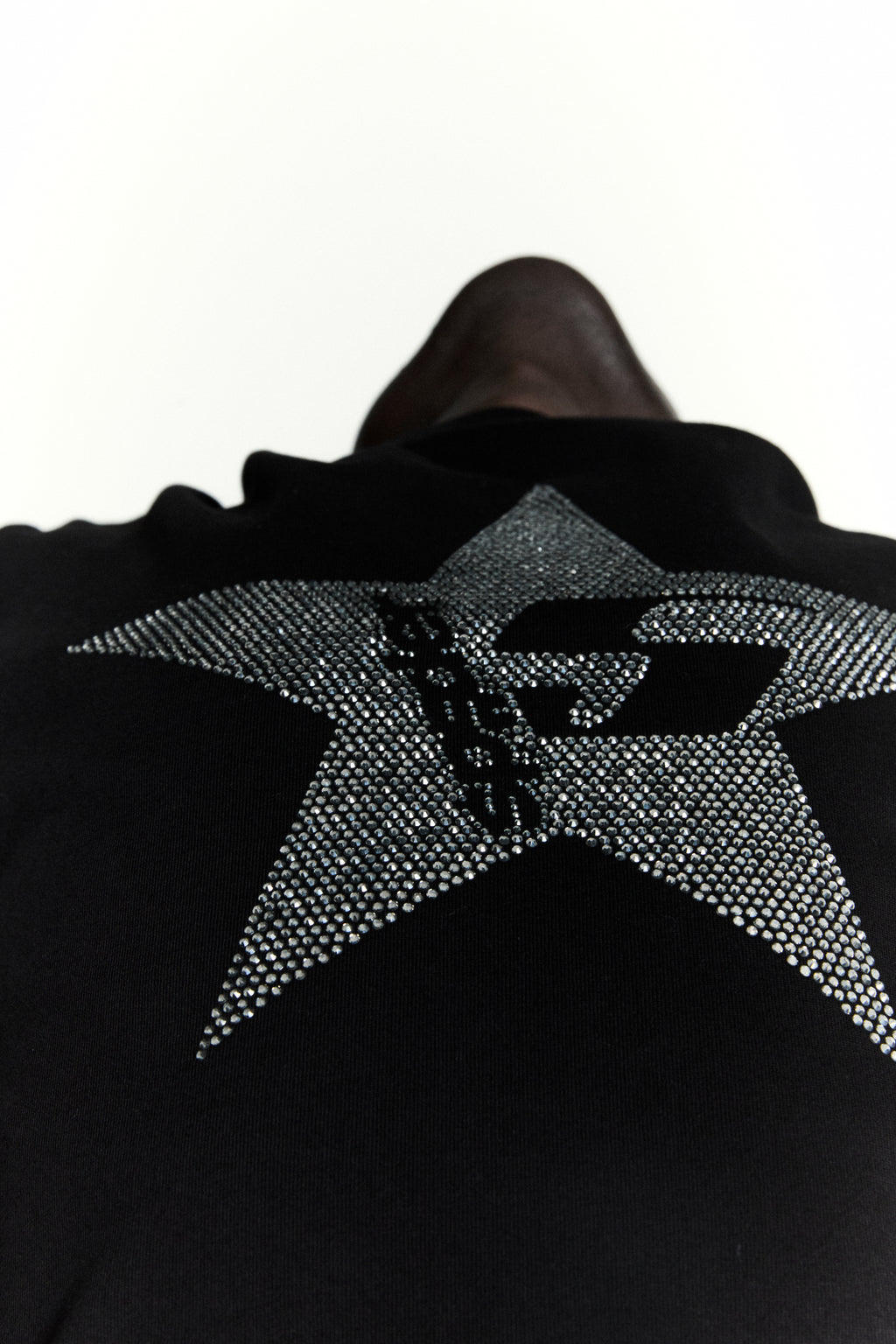 Black 100% cotton tee with a large, sparkly rhinestone 5-star design on the back.