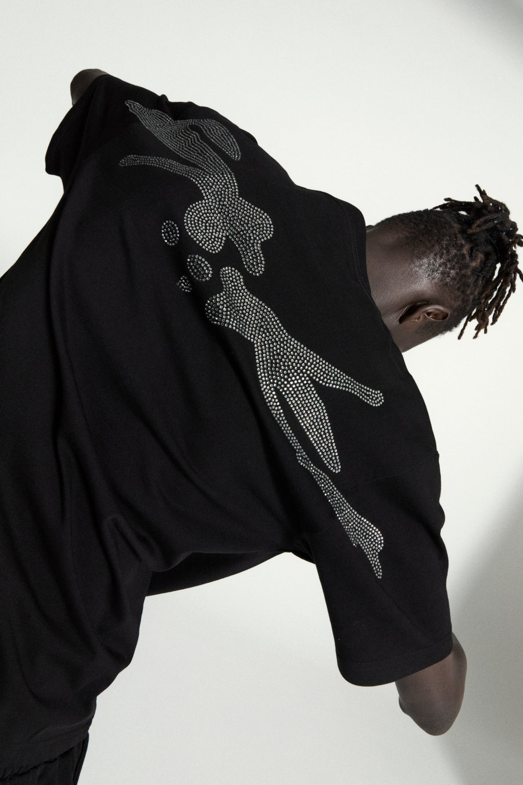 Black cotton tee with a large, silver rhinestone skeleton graphic on the back.