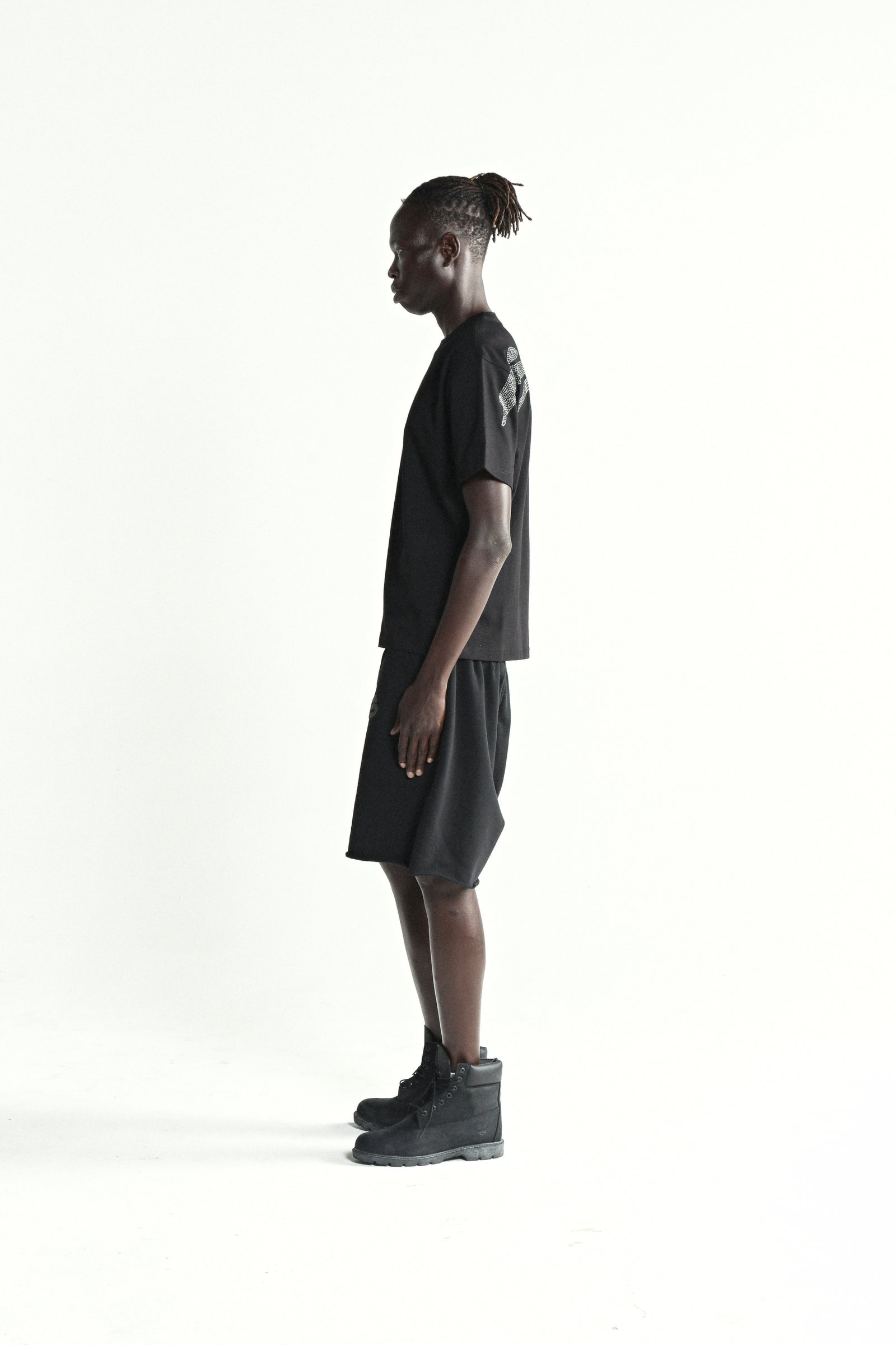 Black cotton rhinestone tee and shorts on a male model, side view.