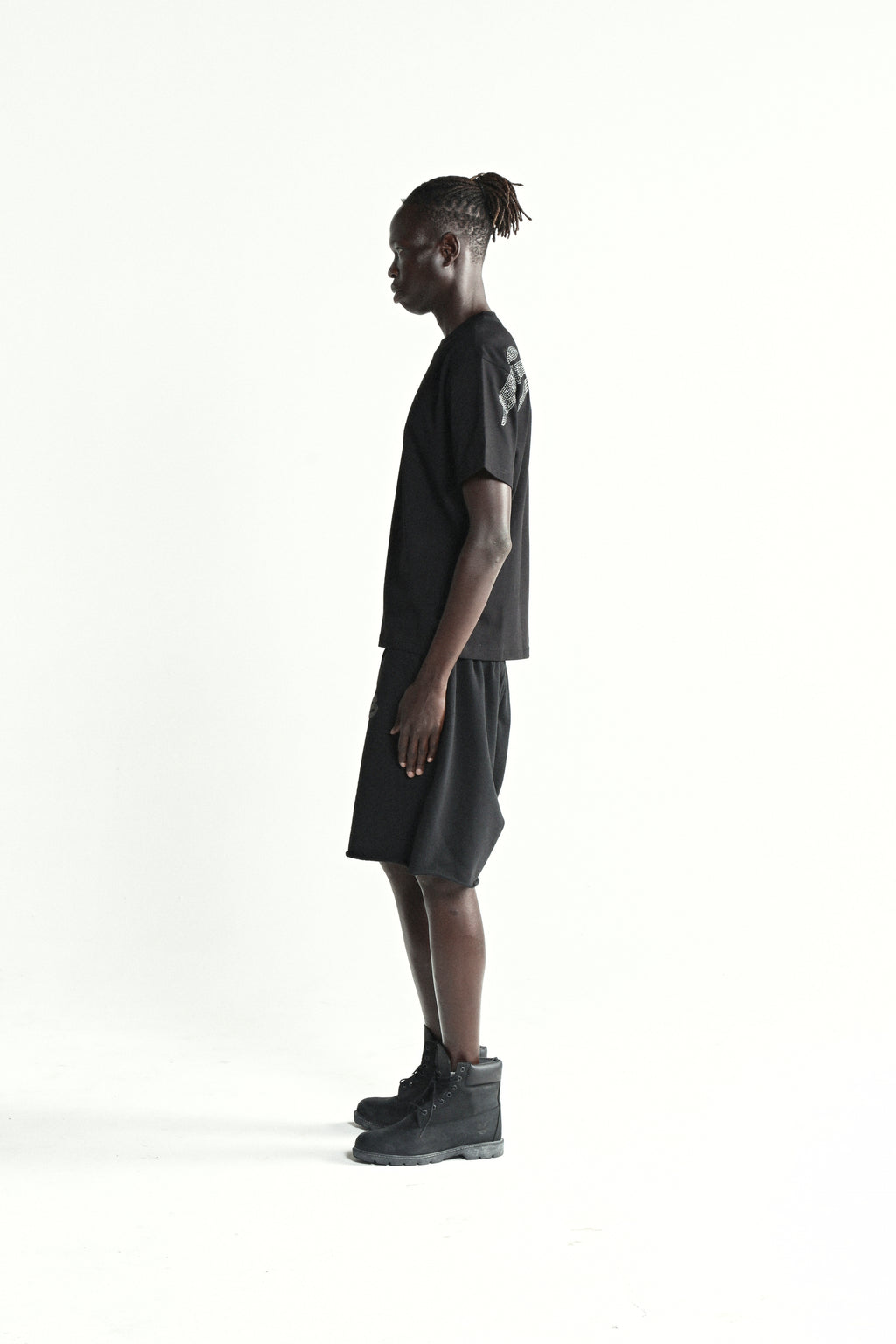 Black cotton rhinestone tee and shorts on a male model, side view.