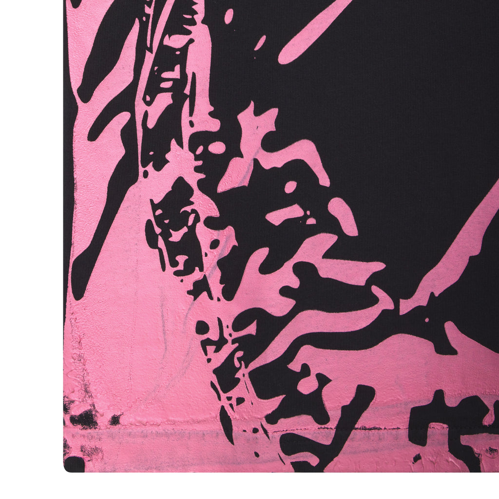 Close-up of a black cotton JERSEY OVERPRINT TEE with a bold pink graphic print.