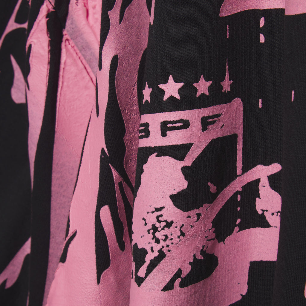 Black cotton tee with bold pink graphic print and trompe l'œil design.