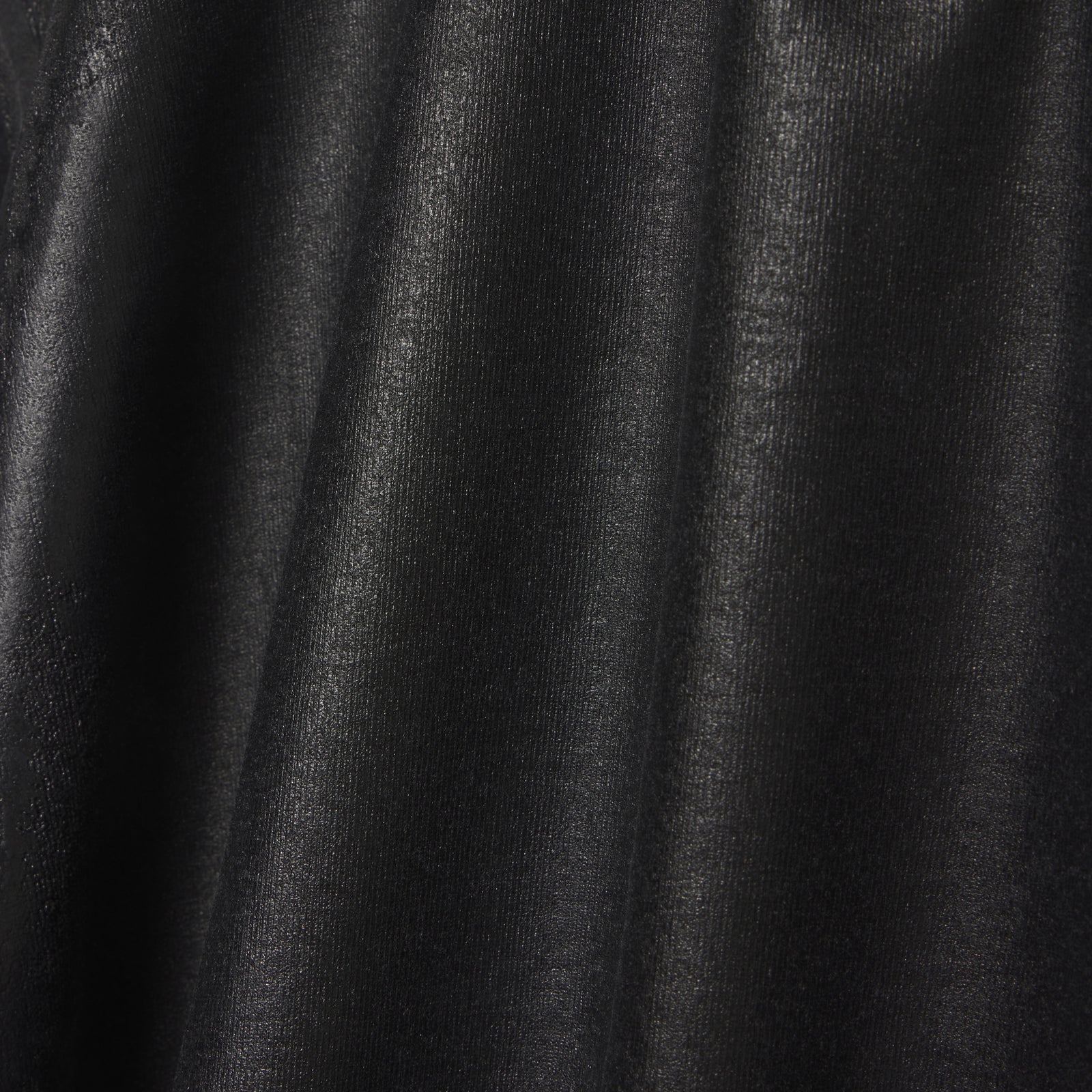 Close-up of black 100% cotton OVERPRINT ARAIGNEE TEE with subtle texture and folds.