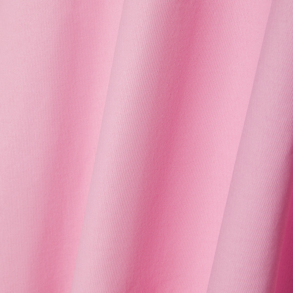 Close-up of a pink 100% cotton tee with a subtle fabric texture and soft folds.