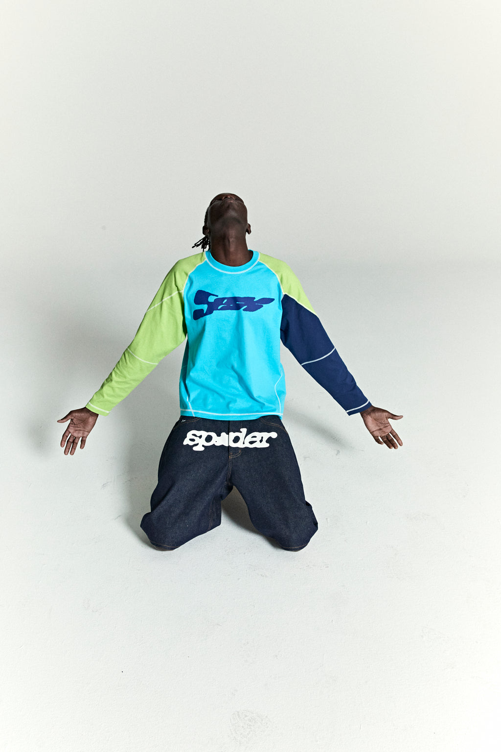 Technomarine cotton color block raglan longsleeve with print and top stitching, paired with dark denim pants.