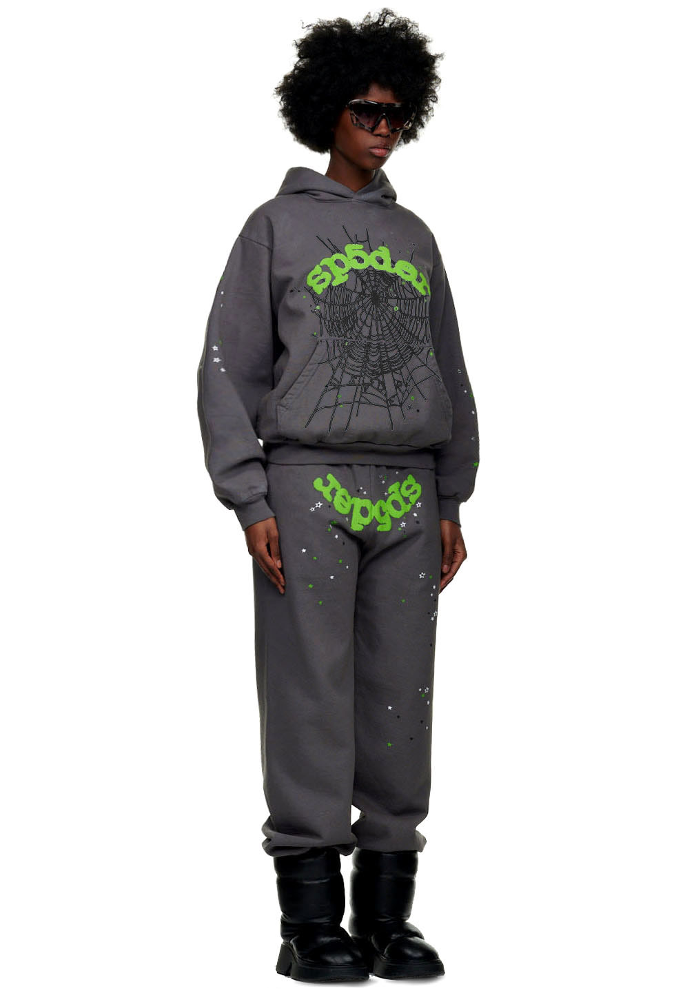 Female model in a grey WAIT WEB SWEATPANT set with green puff print SP5DER text, spiderweb, and stars.