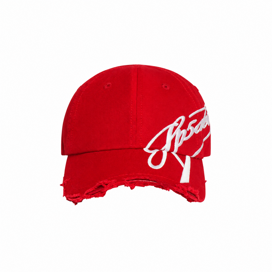 Red baseball cap with a curved brim, distressed edge detailing, and white cursive graphic embroidery extending to the side.