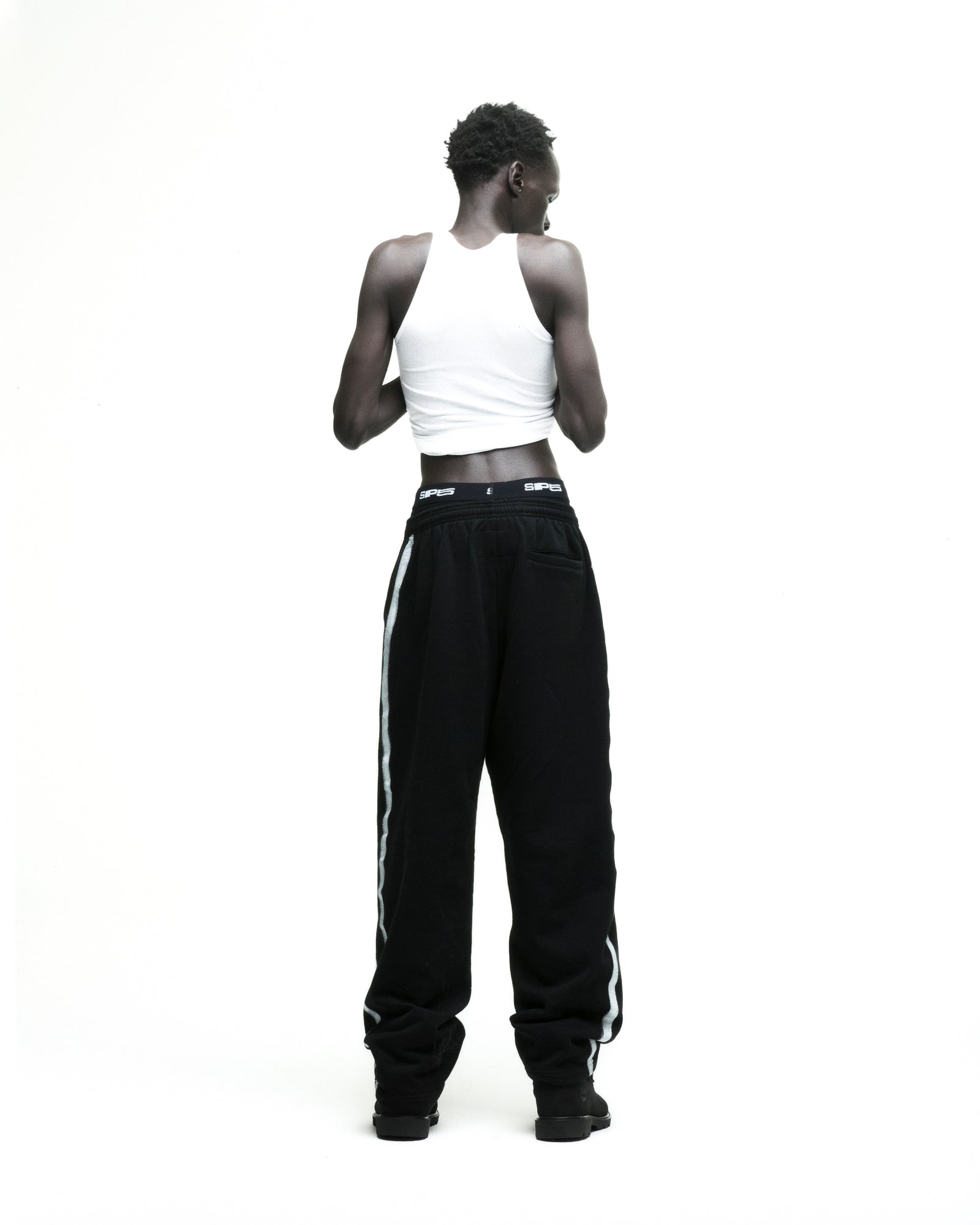 Black Screaming Eagle sweatpants with sprayed-effect side stripe and wide-leg silhouette.