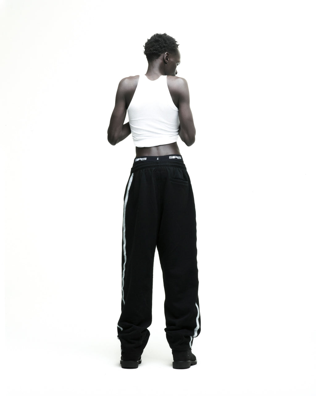 Black Screaming Eagle sweatpants with sprayed-effect side stripe and wide-leg silhouette.
