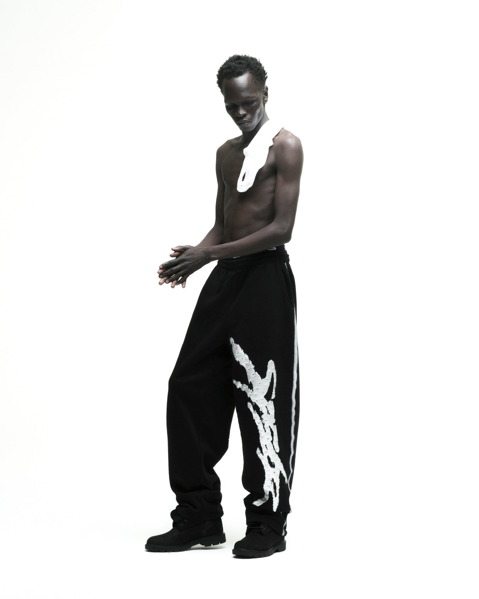 Black cotton fleece wide-leg sweatpants with white sprayed-effect side stripe and rhinestone "SP5DER" logo.