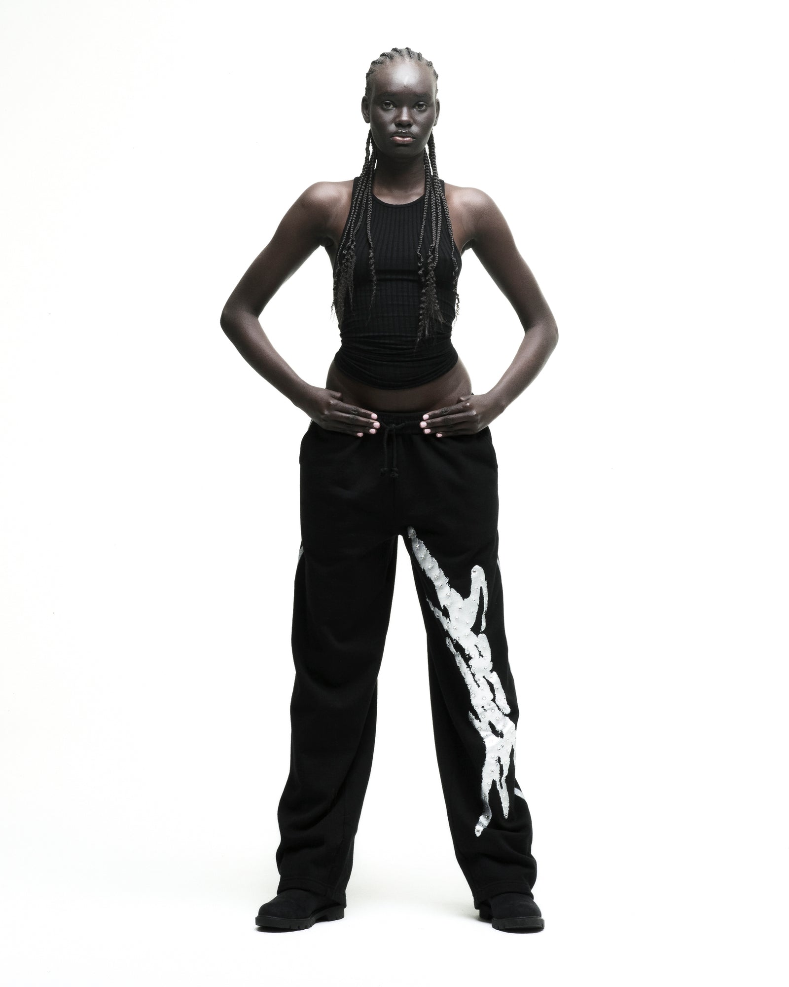 Black cotton fleece sweatpants with rhinestone SP5DER logo and sprayed-effect white side stripe.