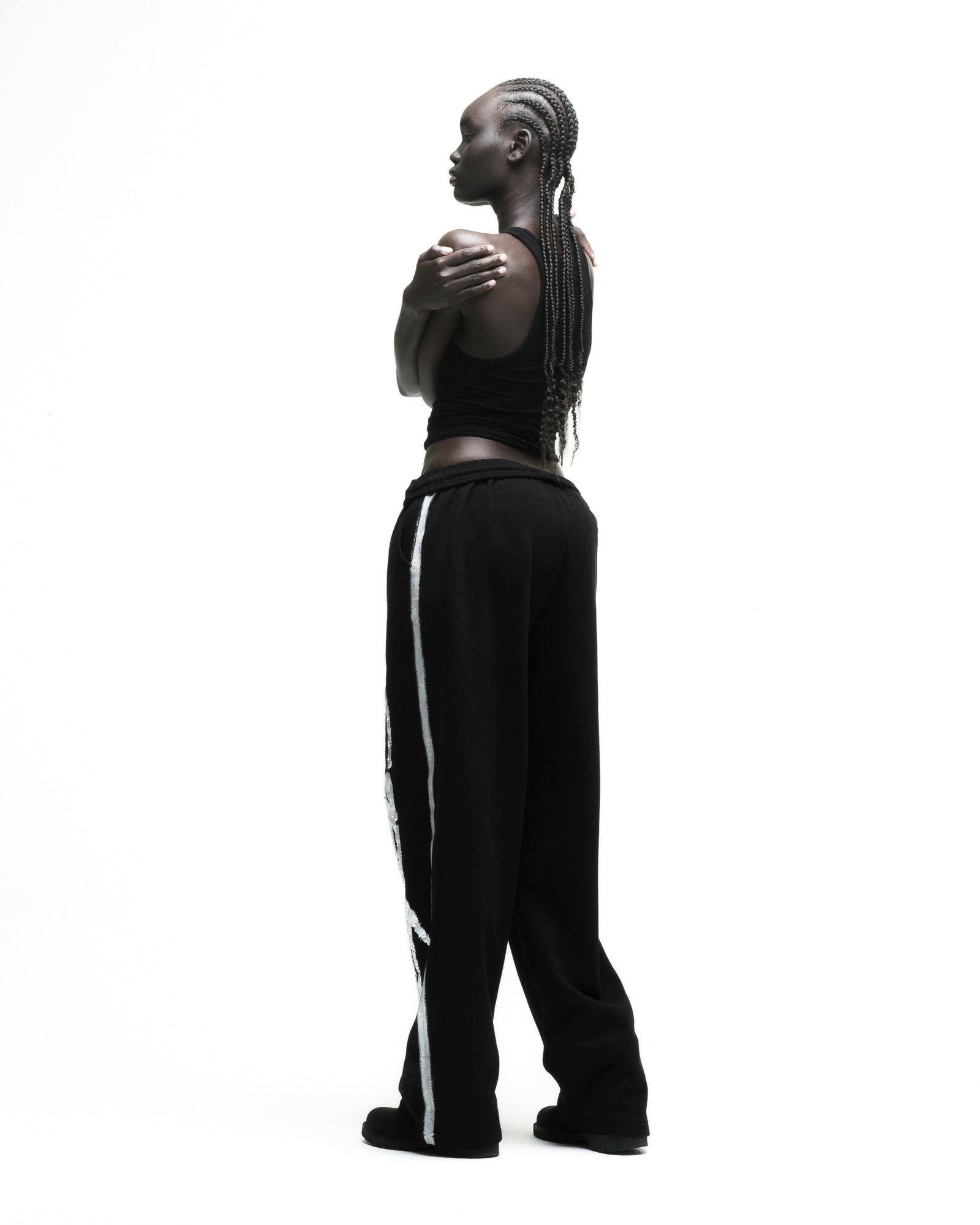 Black cotton fleece sweatpants with sprayed-effect side stripe and wide-leg silhouette.