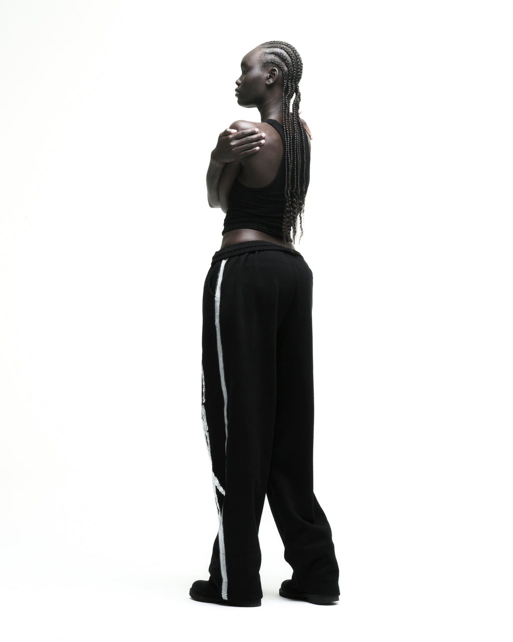 Black cotton fleece sweatpants with sprayed-effect side stripe and wide-leg silhouette.
