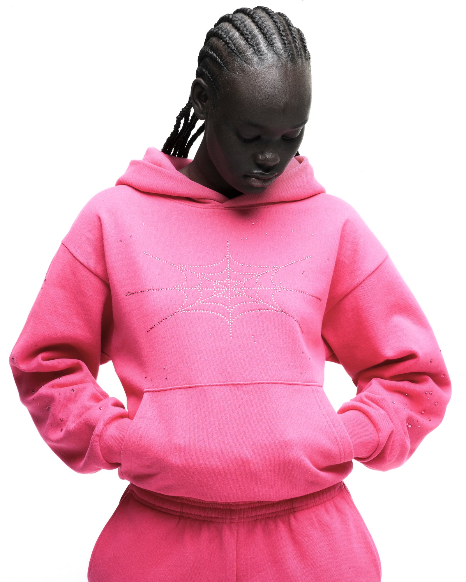 Pink cotton fleece hoodie with rhinestone spiderweb design and kangaroo pocket.