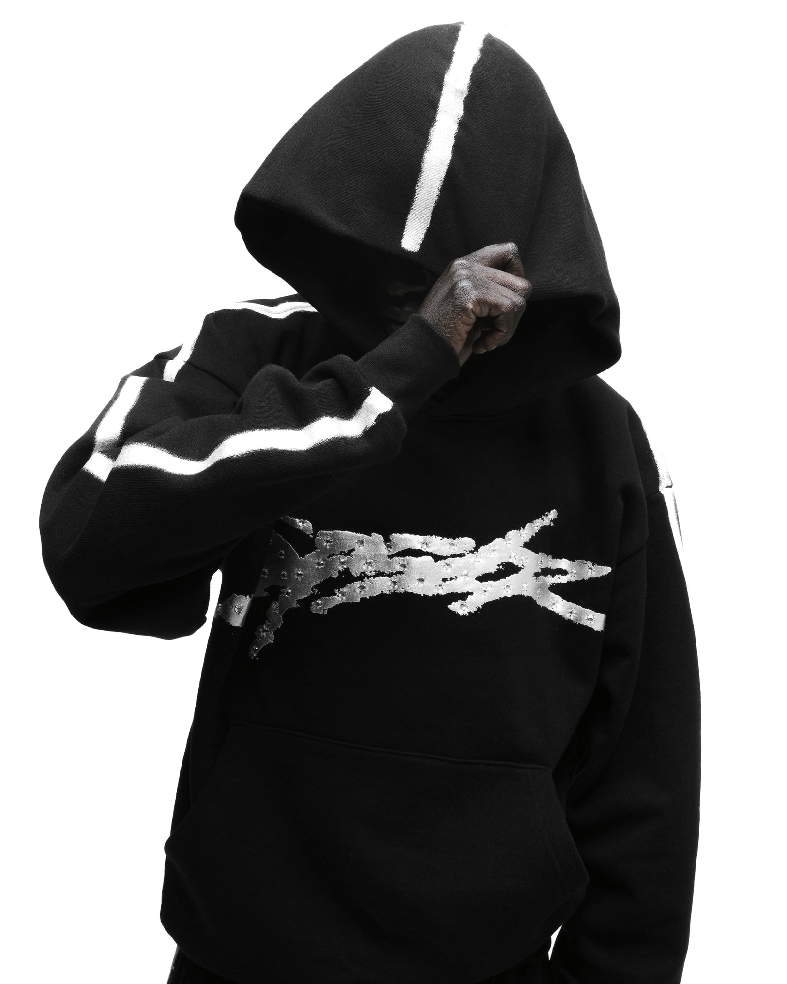 Black cotton fleece hoodie with metallic "SP5DER" logo, rhinestone accents, and sprayed white stripes.