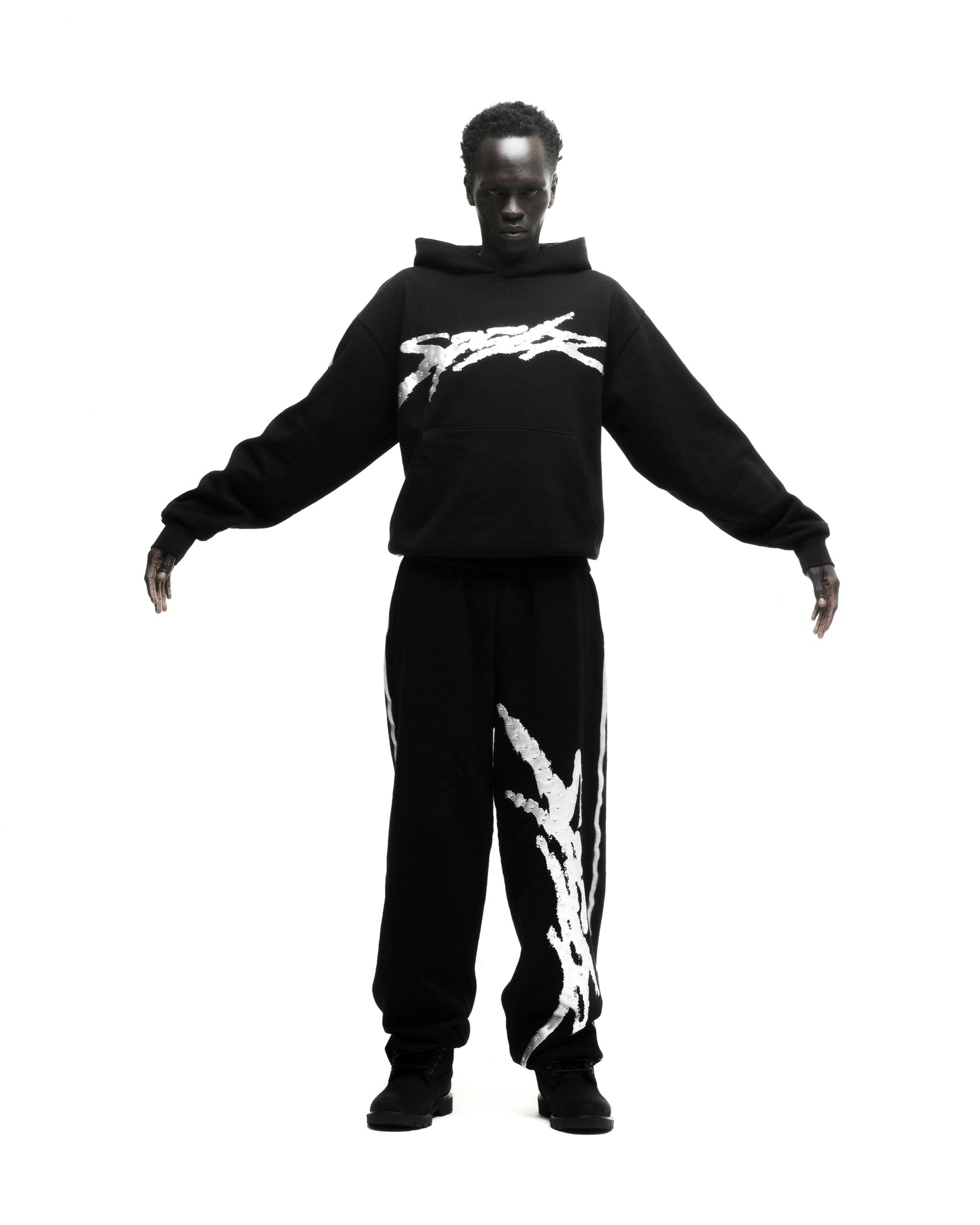 Black cotton fleece hoodie and sweatpants set with white sprayed-effect graphics.