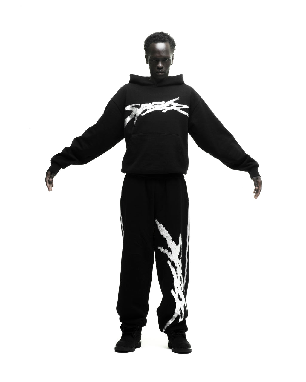 Black cotton fleece hoodie and sweatpants set with white sprayed-effect graphics.