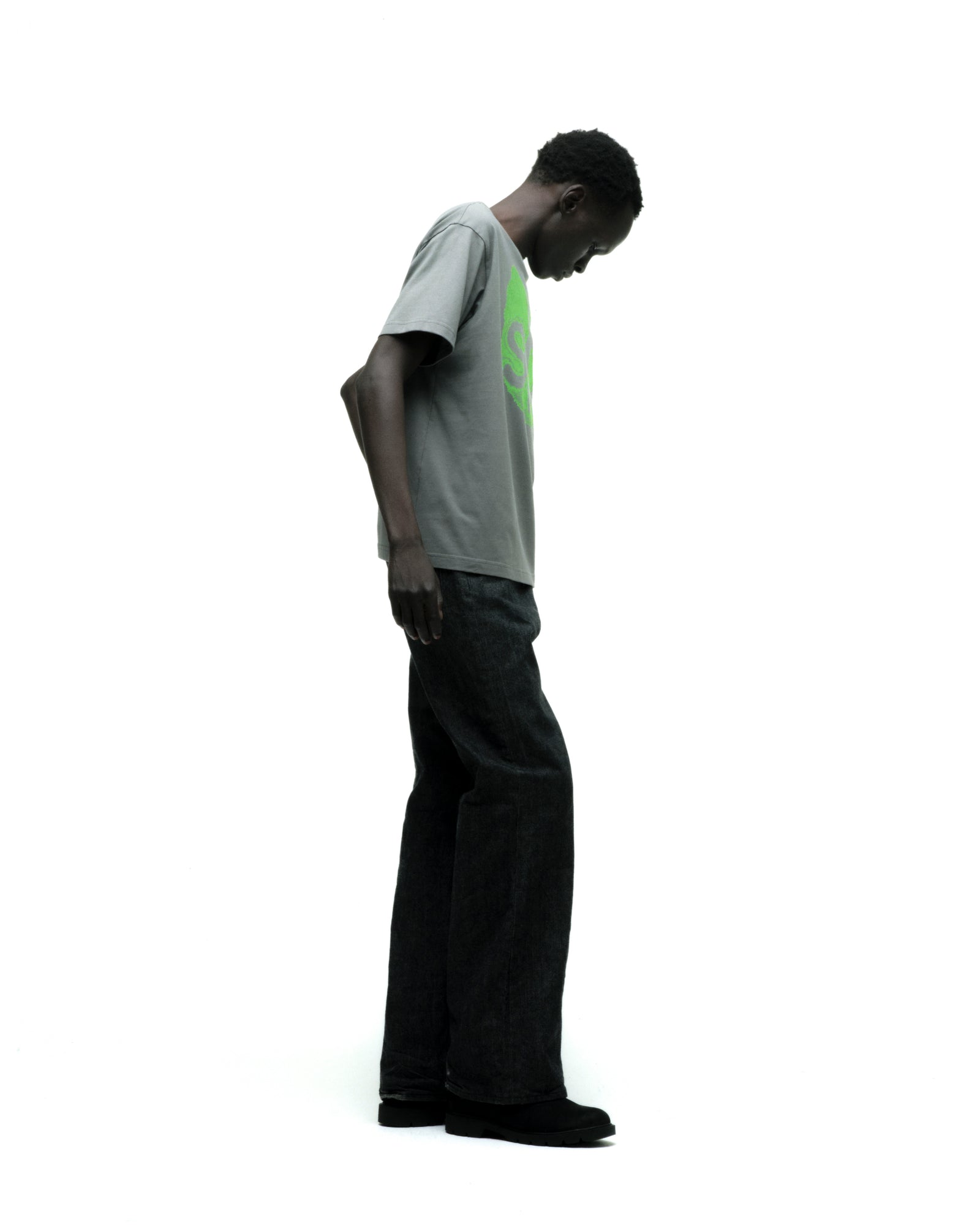 Man wearing a gray cotton FINGERPRINT TEE with a bright green graphic print and dark jeans.