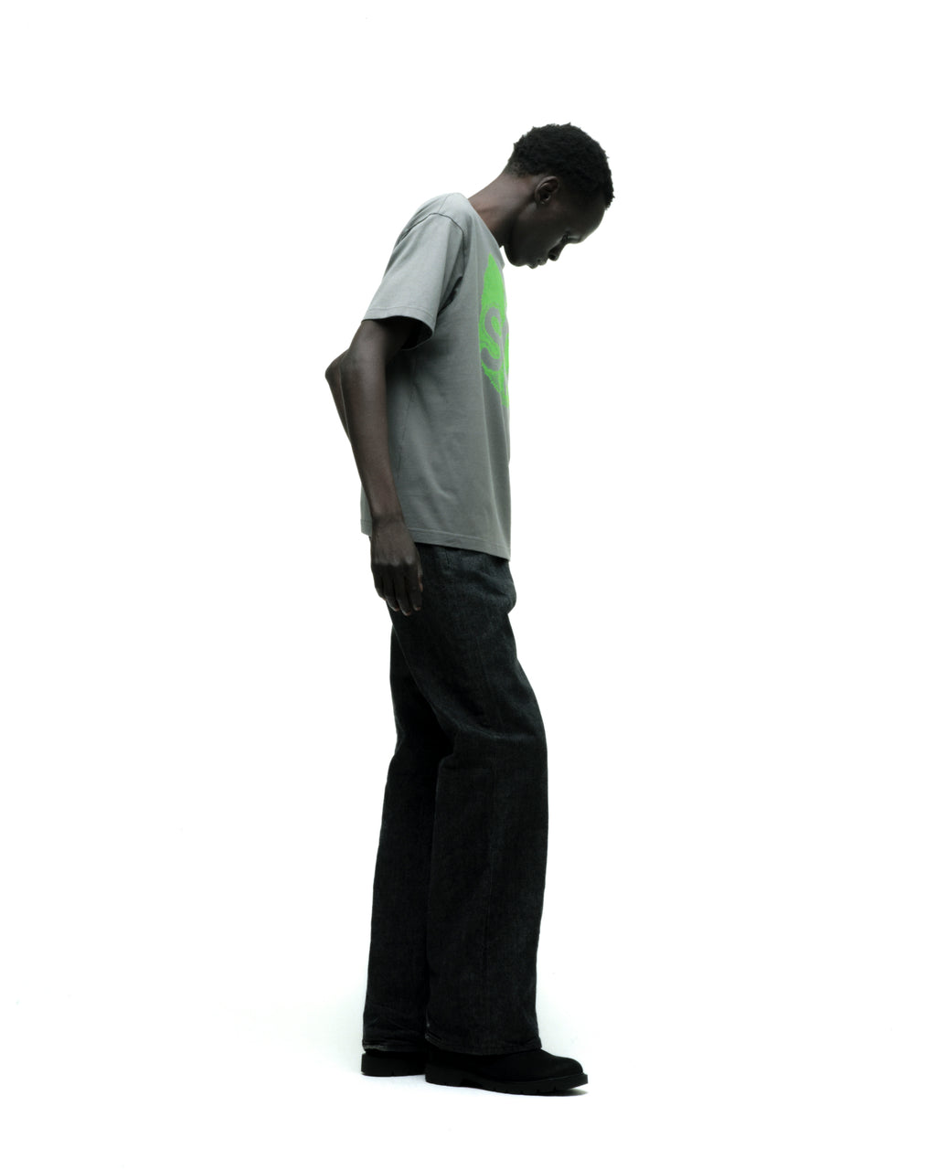 Man wearing a gray cotton FINGERPRINT TEE with a bright green graphic print and dark jeans.