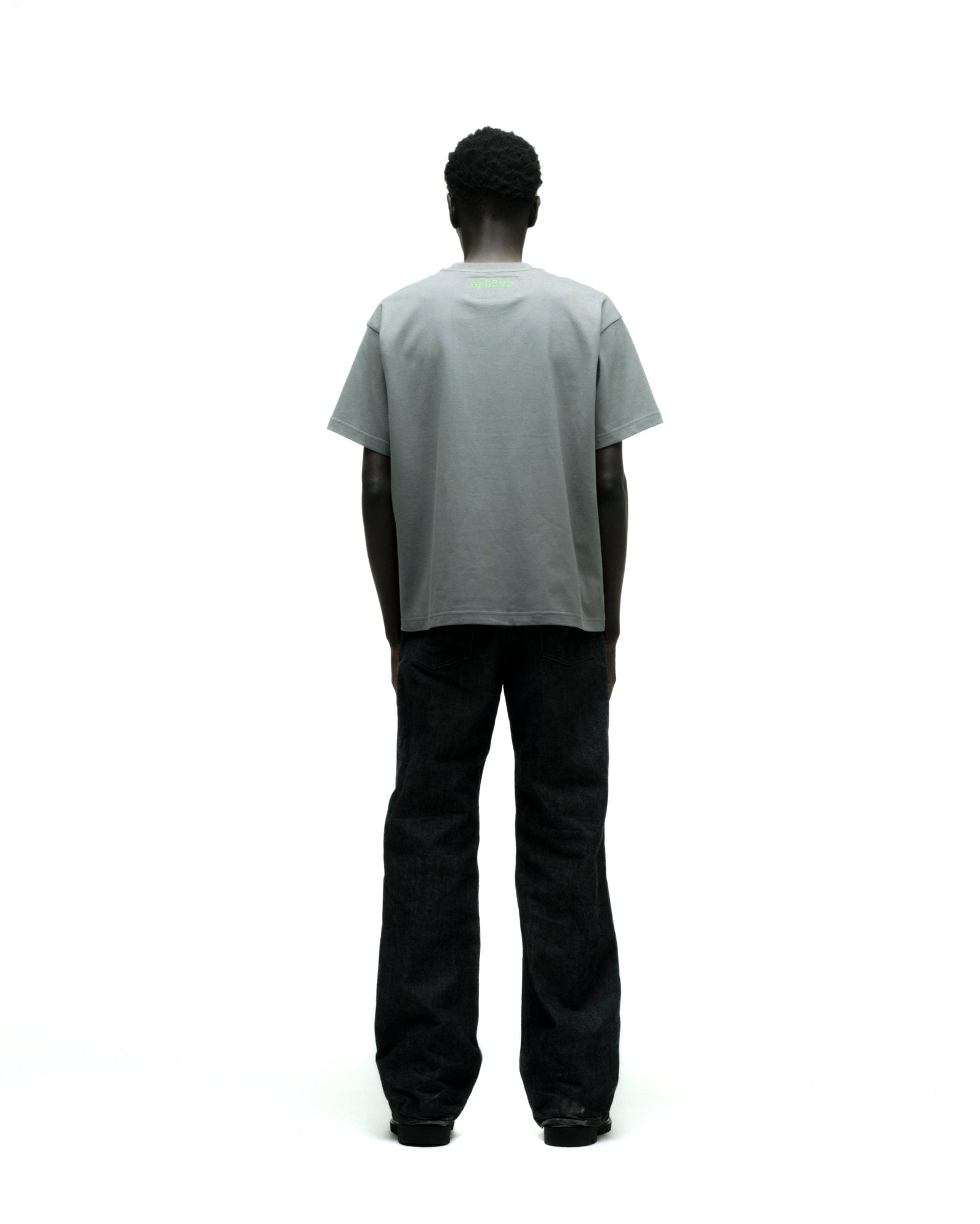 Gray cotton FINGERPRINT TEE with green graphic print on back, worn by a person in black jeans.