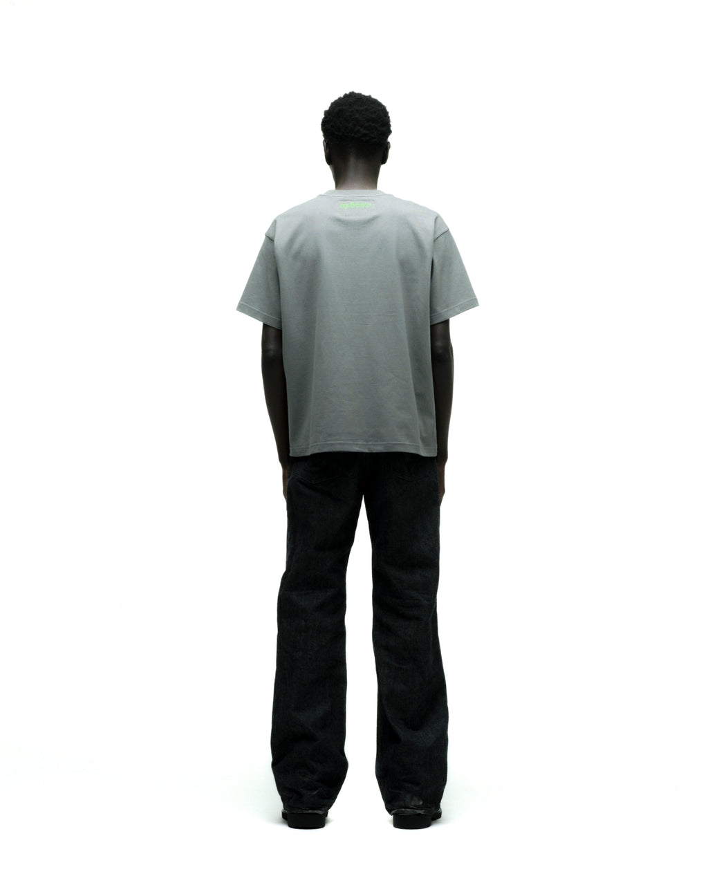 Gray cotton FINGERPRINT TEE with green graphic print on back, worn by a person in black jeans.