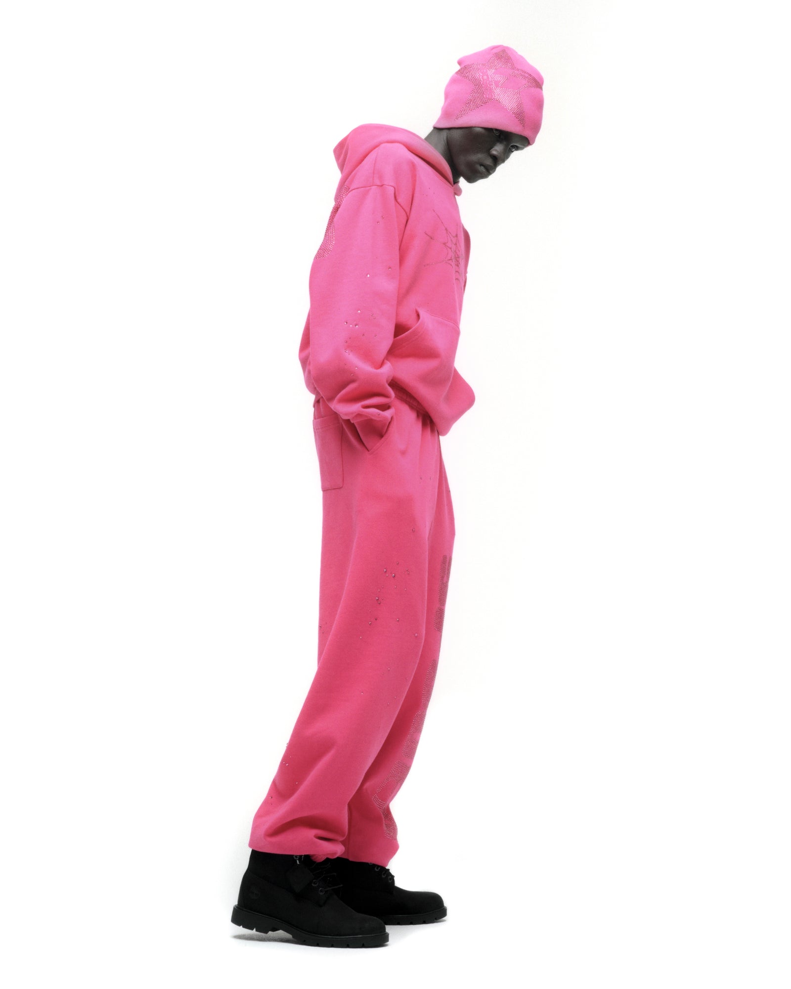 Pink rhinestone silk hoodie and sweatpants set on a model, featuring a kangaroo pocket and rib knit details.