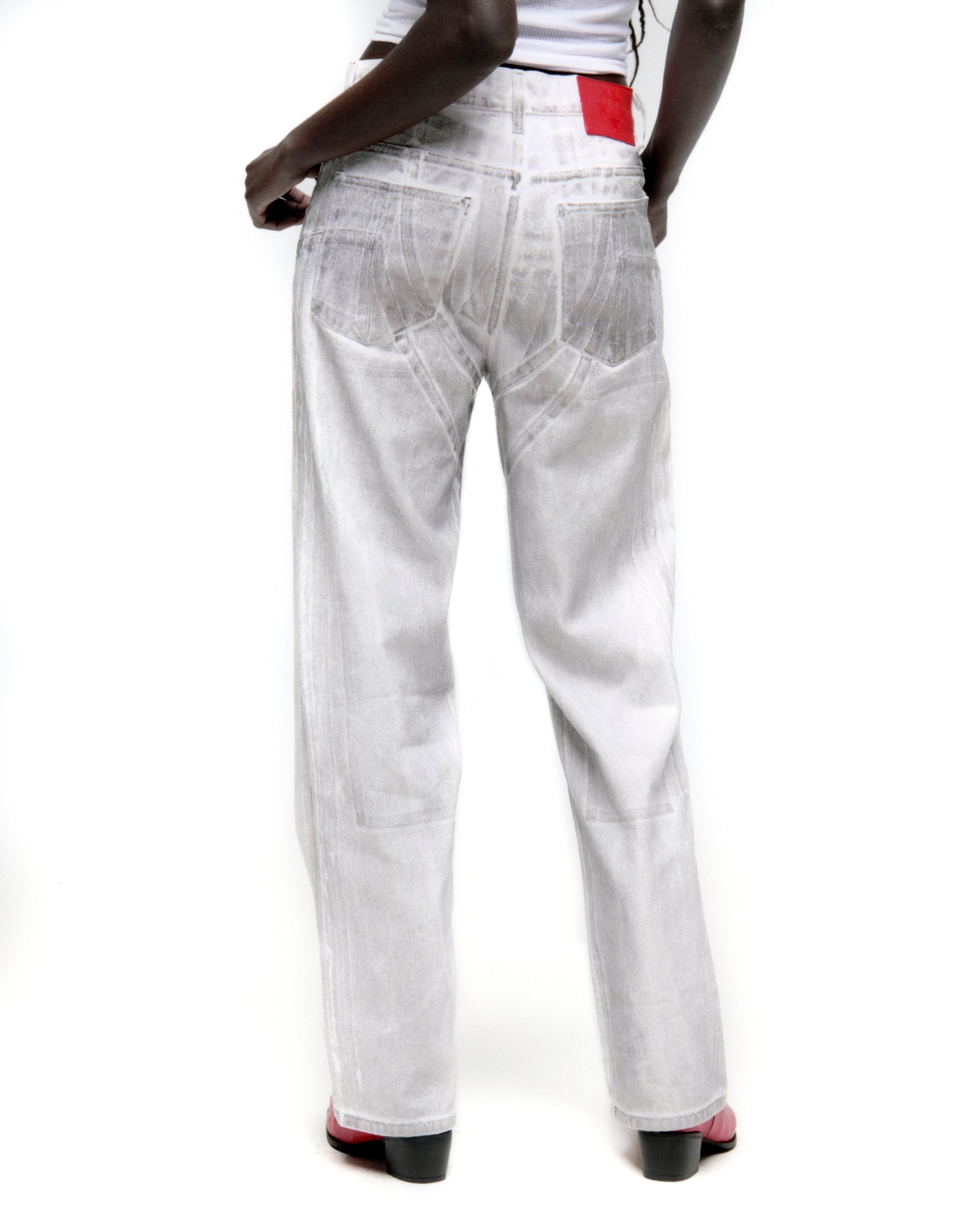Platinum wide-leg denim pant with spray effect, back panels, and red leather patch.