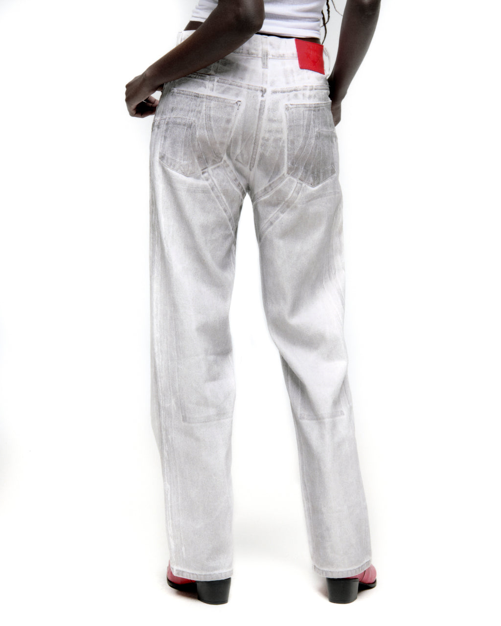 Platinum wide-leg denim pant with spray effect, back panels, and red leather patch.