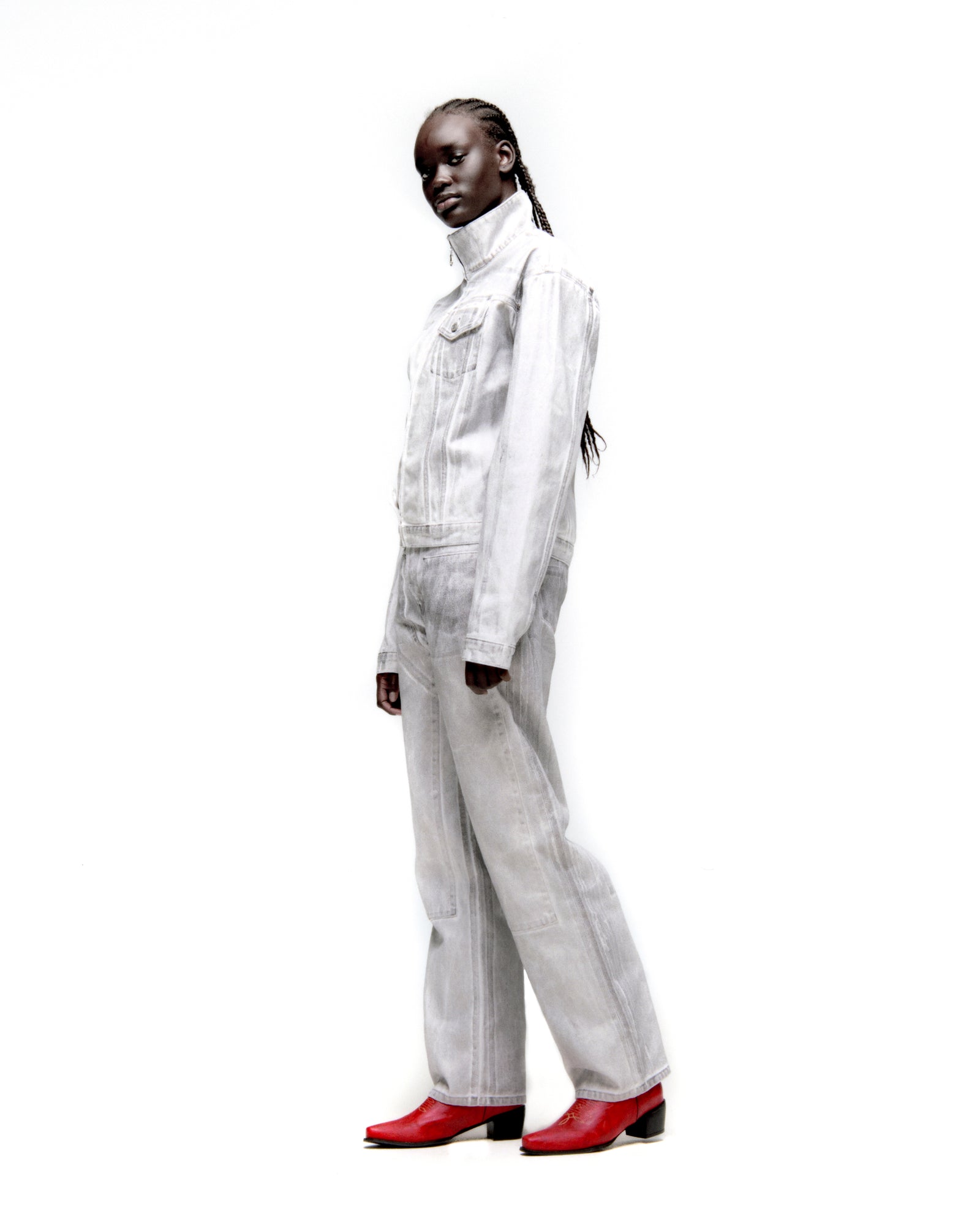 Model wearing a PLATINUM TRUCKER JACKET and matching spray-effect denim jeans with red boots.