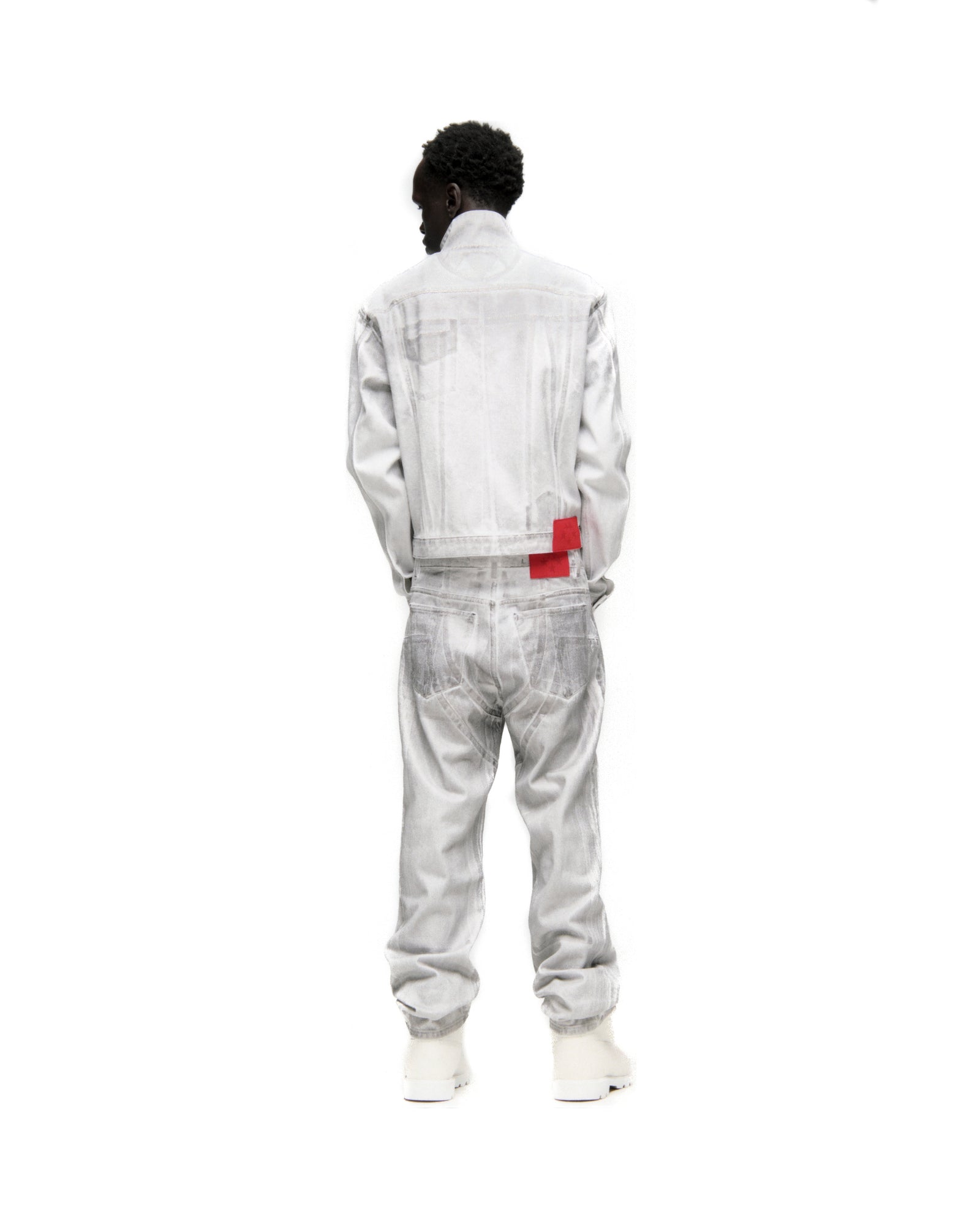 Man in a platinum spray-effect denim trucker jacket and matching jeans with a red back patch.