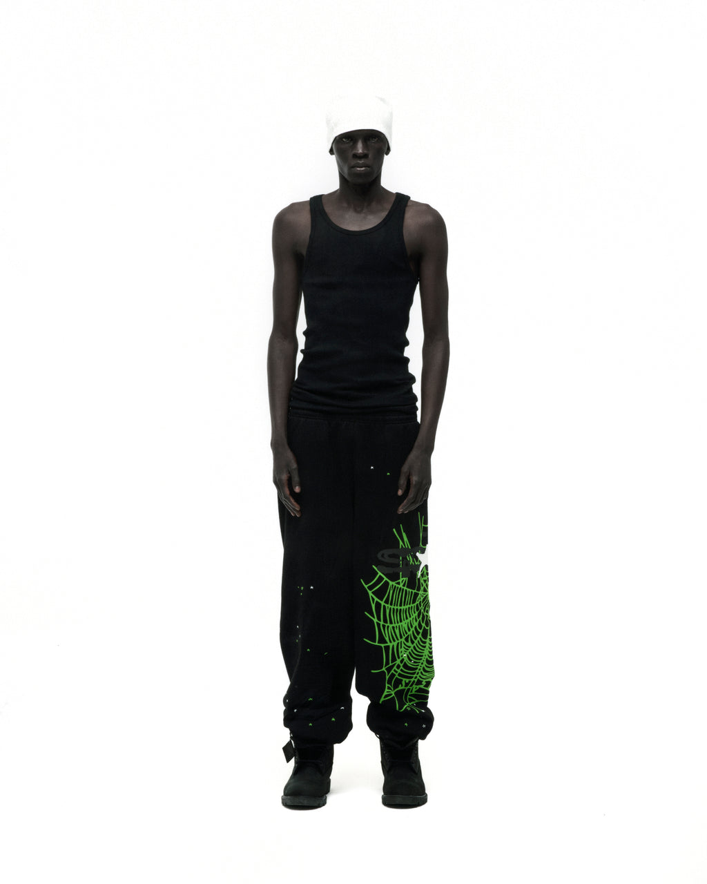 Black HEAVY WEB SWEATPANT with neon green SP5DER web graphic and scattered stars, worn by a model.