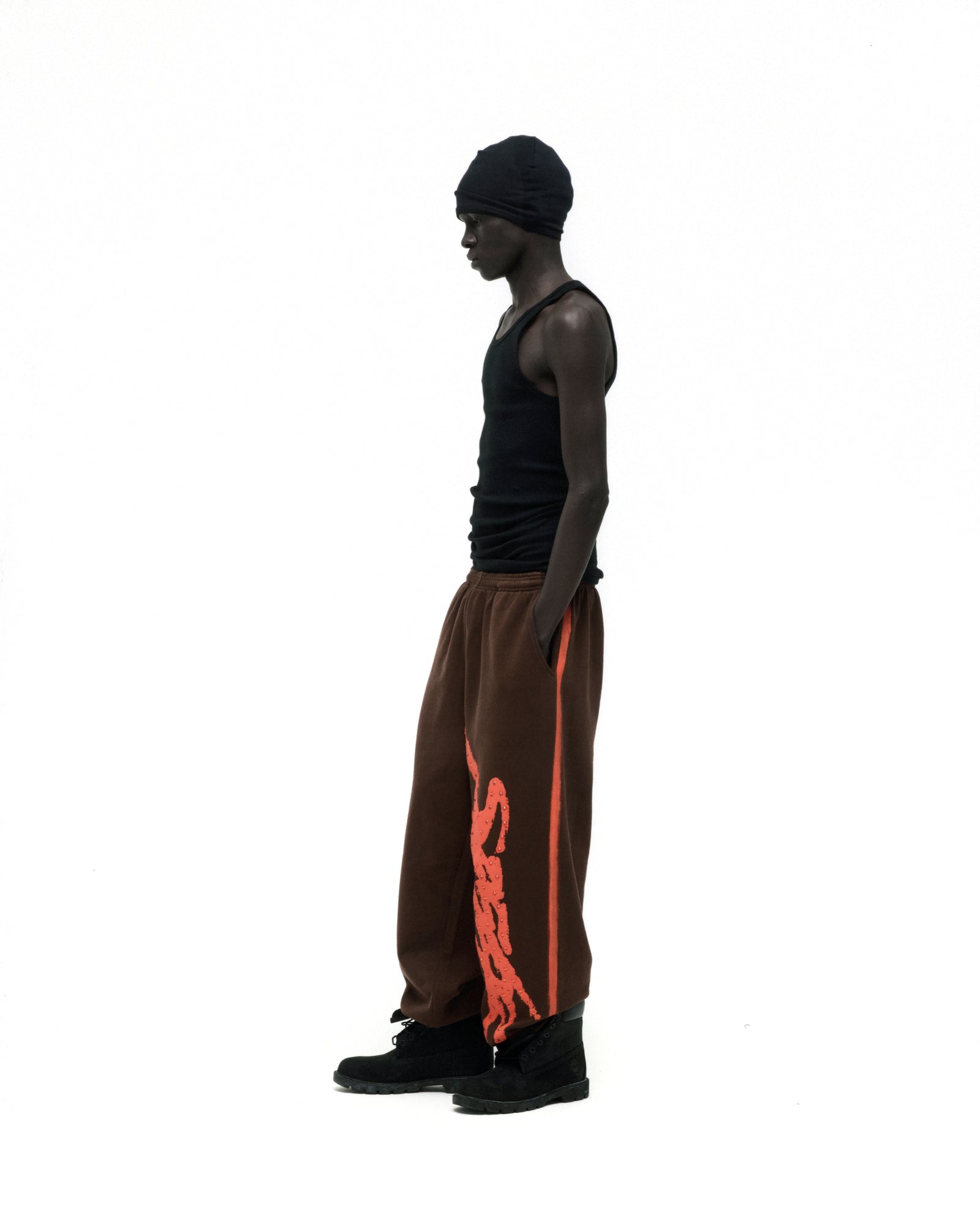 Brown cotton fleece sweatpants with orange "SP5DER" logo and sprayed side stripe.