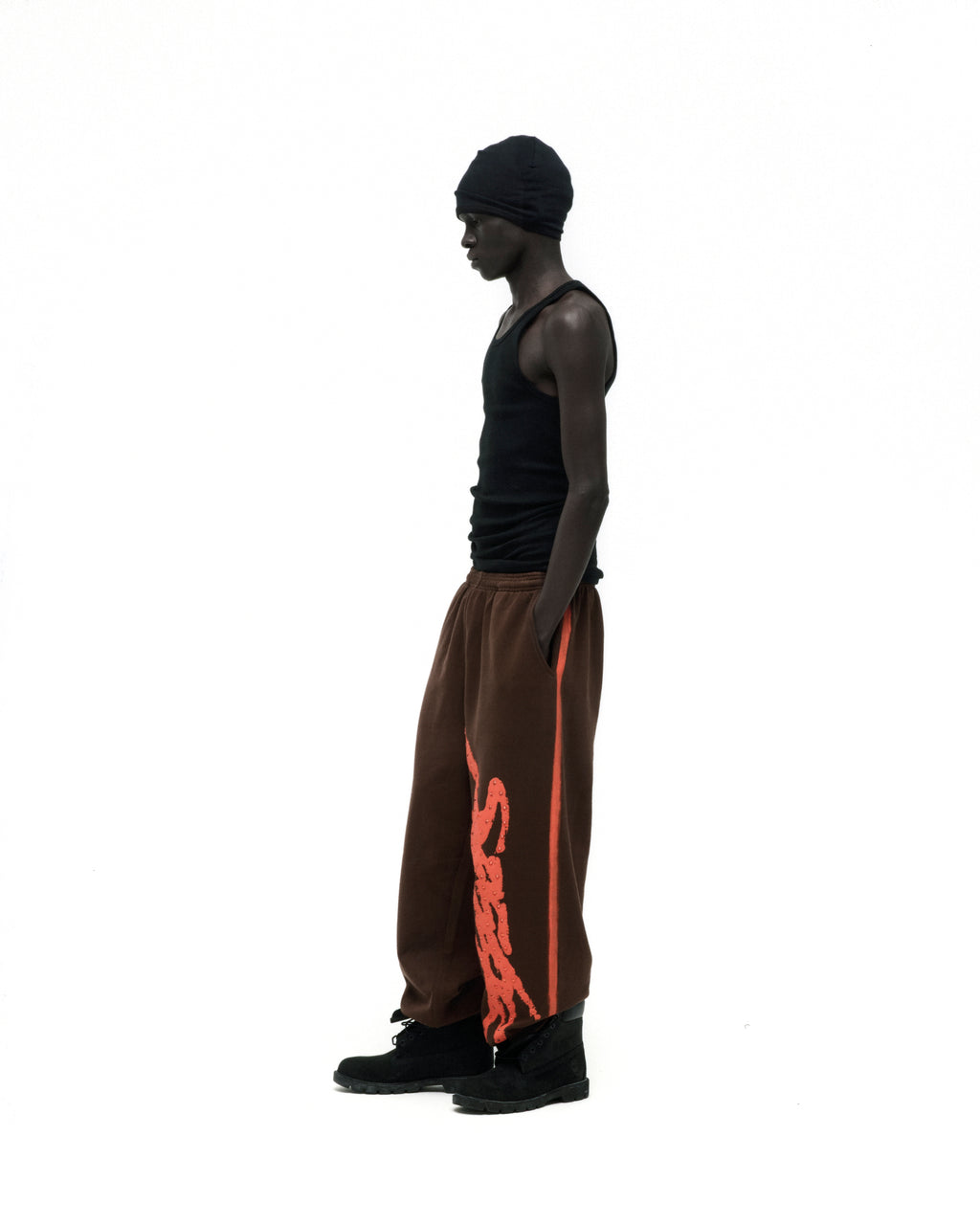 Brown cotton fleece sweatpants with orange "SP5DER" logo and sprayed side stripe.