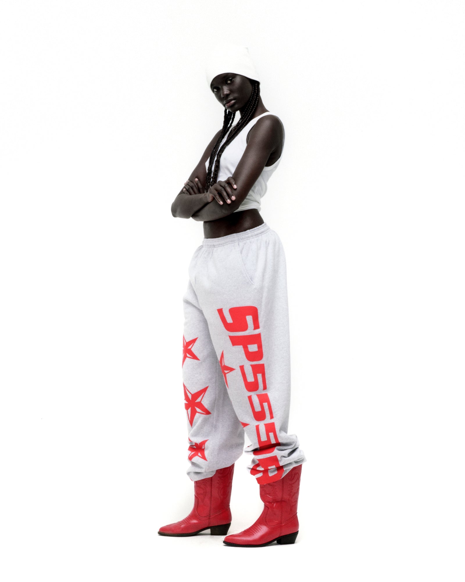 Grey MX555 sweatpants with red foil SP5DER logo and star print, wide-leg, on a model.