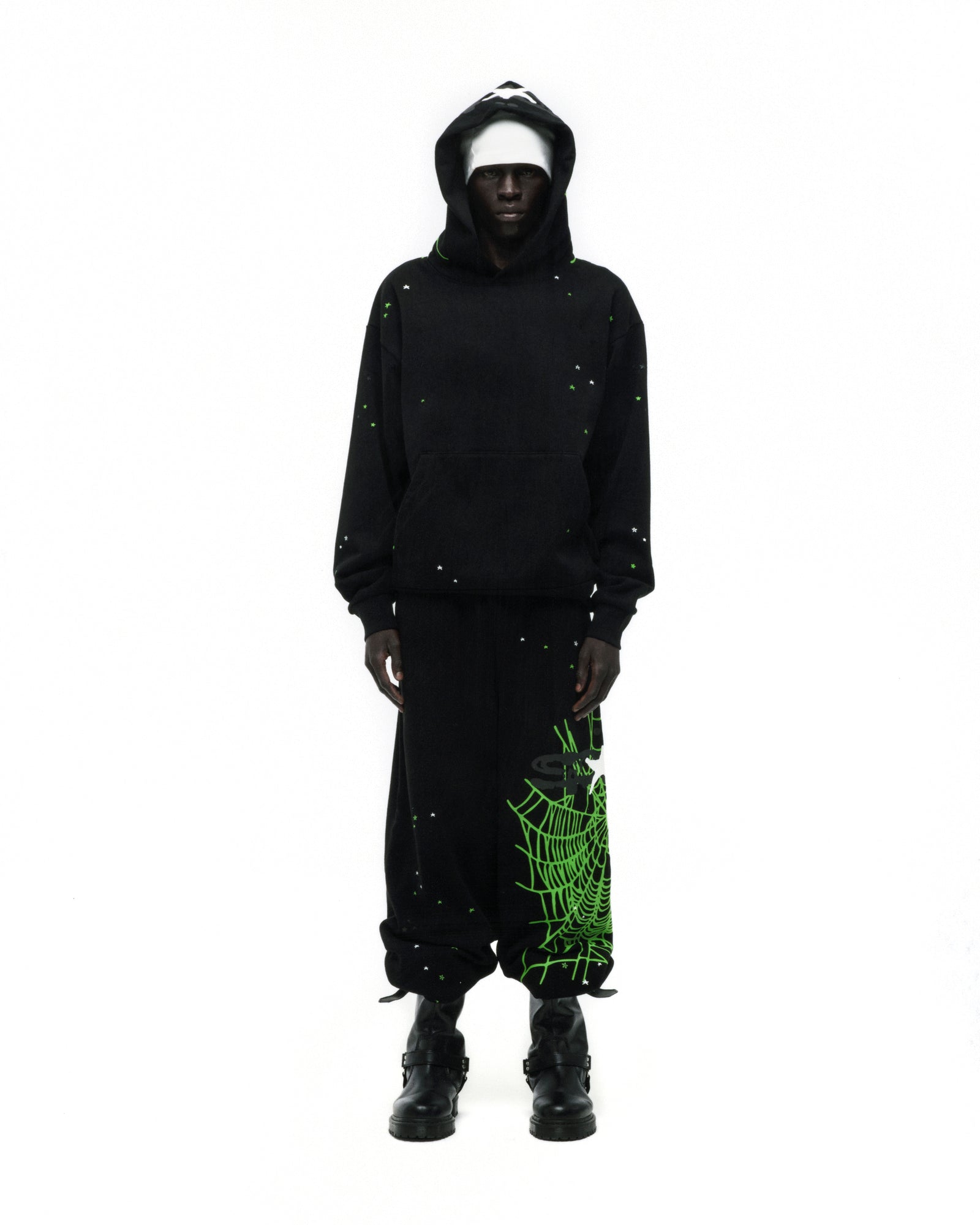 Black heavy web hoodie with scattered star print, green web print on hood, and matching sweatpants.