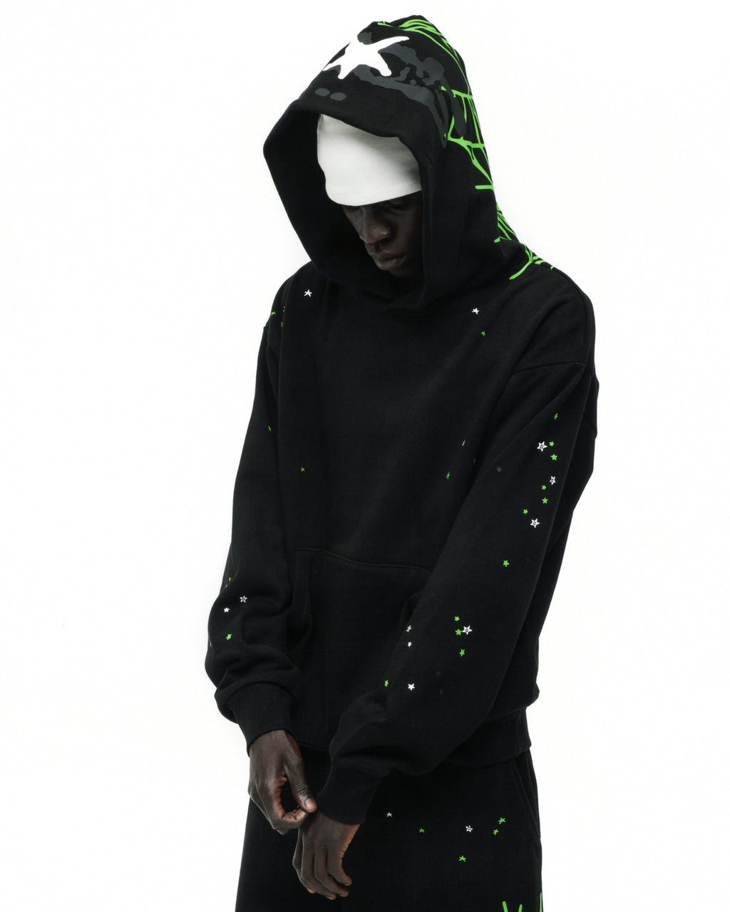 Black heavy web hoodie with green web print on hood, white stars on hood and scattered on front.